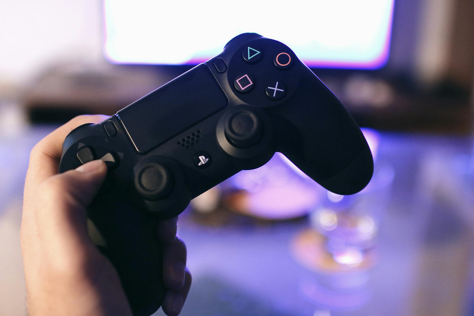 Ein Mann hält einen PlayStation-Controller | Quelle: Pexels