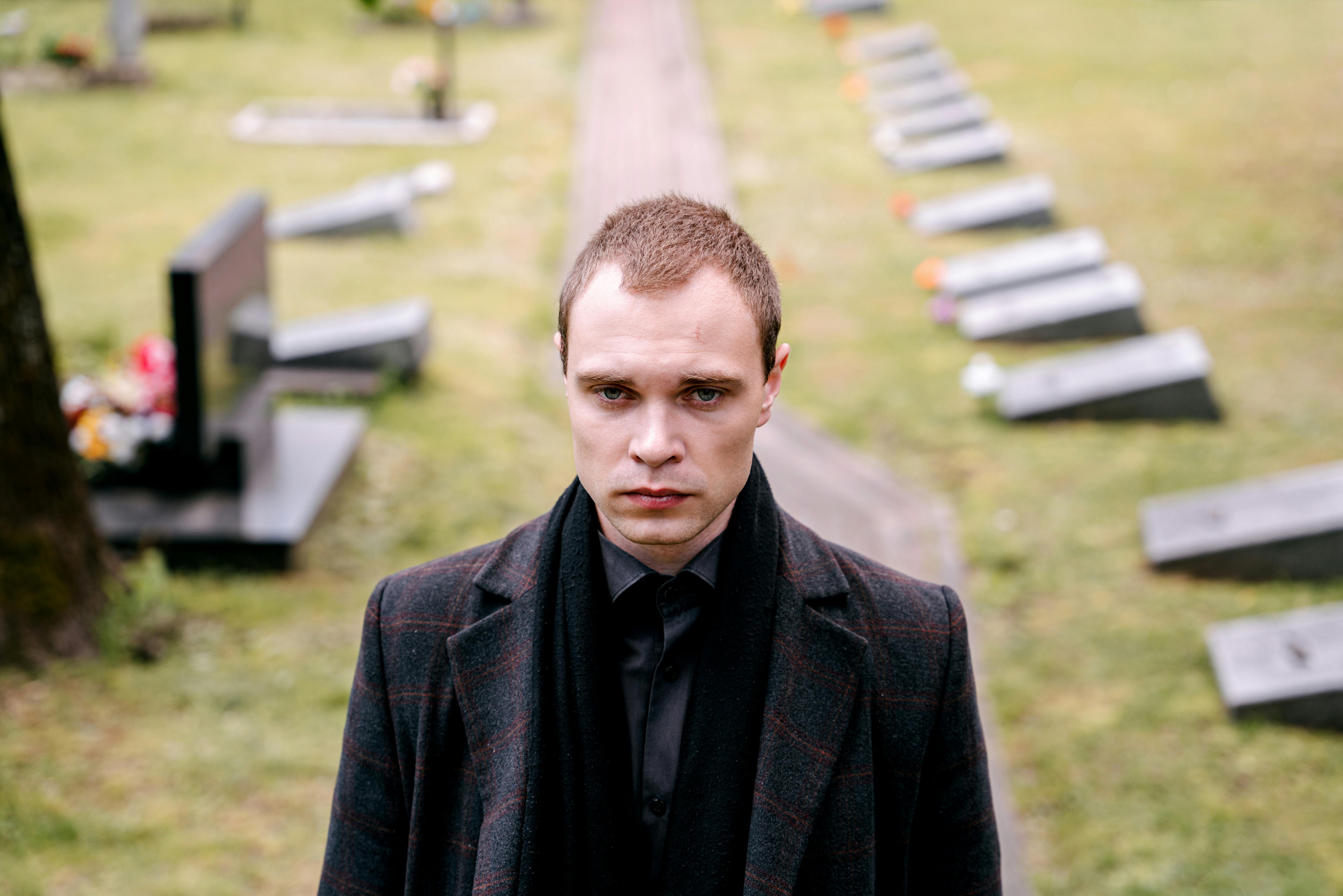 Ein Mann steht auf einem Friedhof | Quelle: Pexels