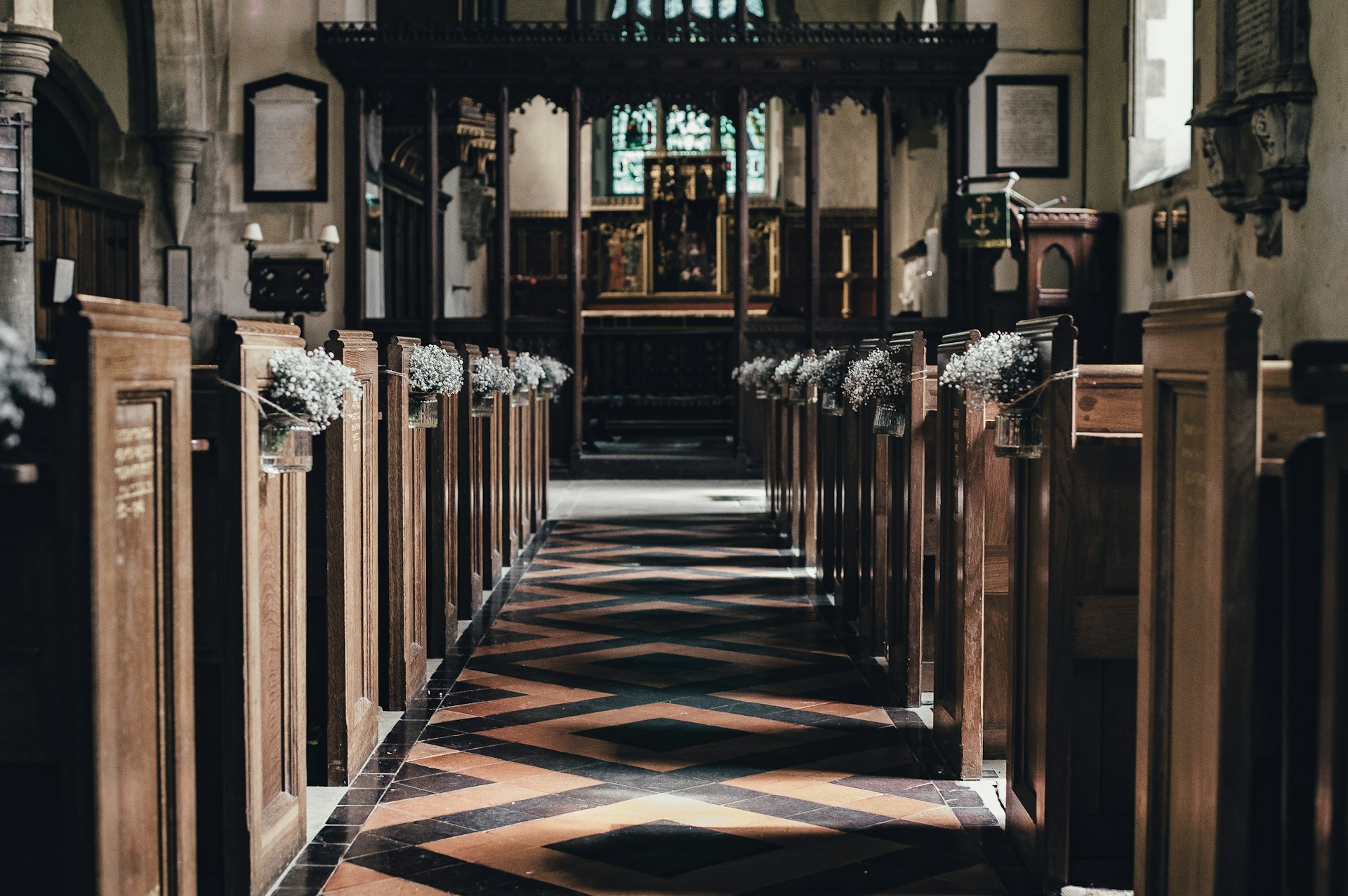 Der Gang in einer für eine Hochzeit geschmückten Kirche | Quelle: Unsplash