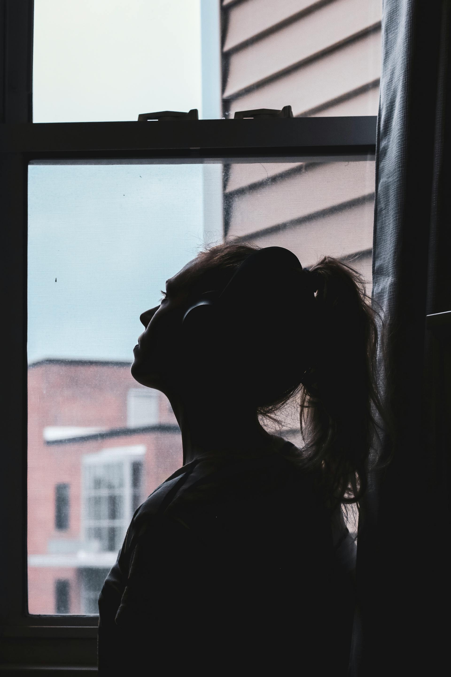Eine junge Frau schaut durch das Fenster | Quelle: Pexels