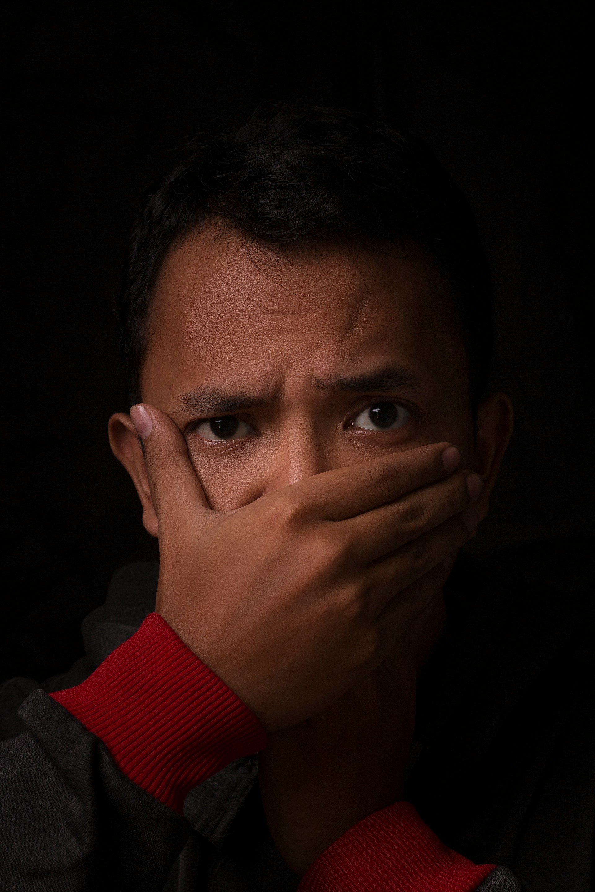 Ein Mann, der seinen Mund mit einer Hand bedeckt | Quelle: Unsplash