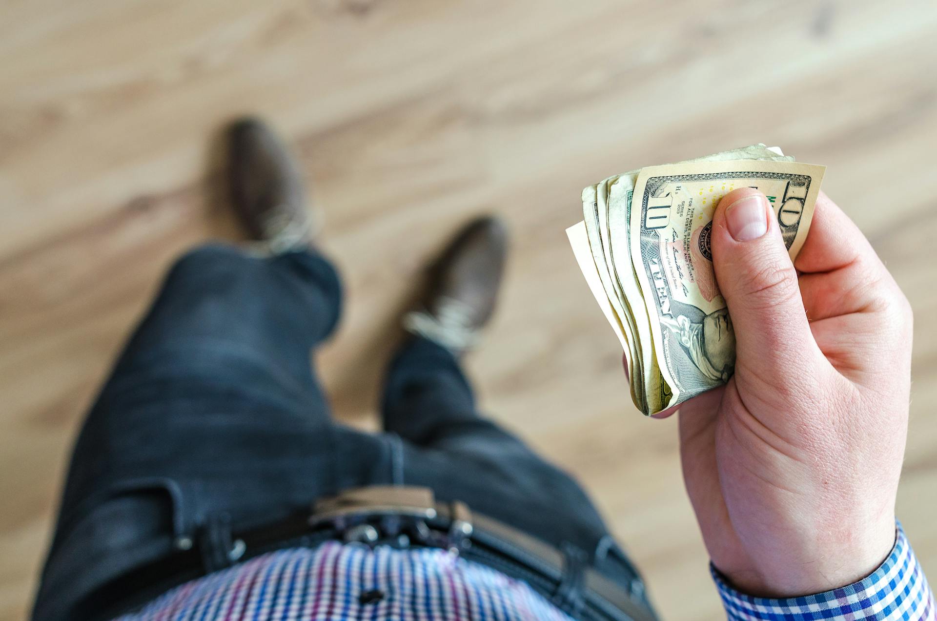 Ein Mann mit Dollarscheinen in der Hand | Quelle: Pexels