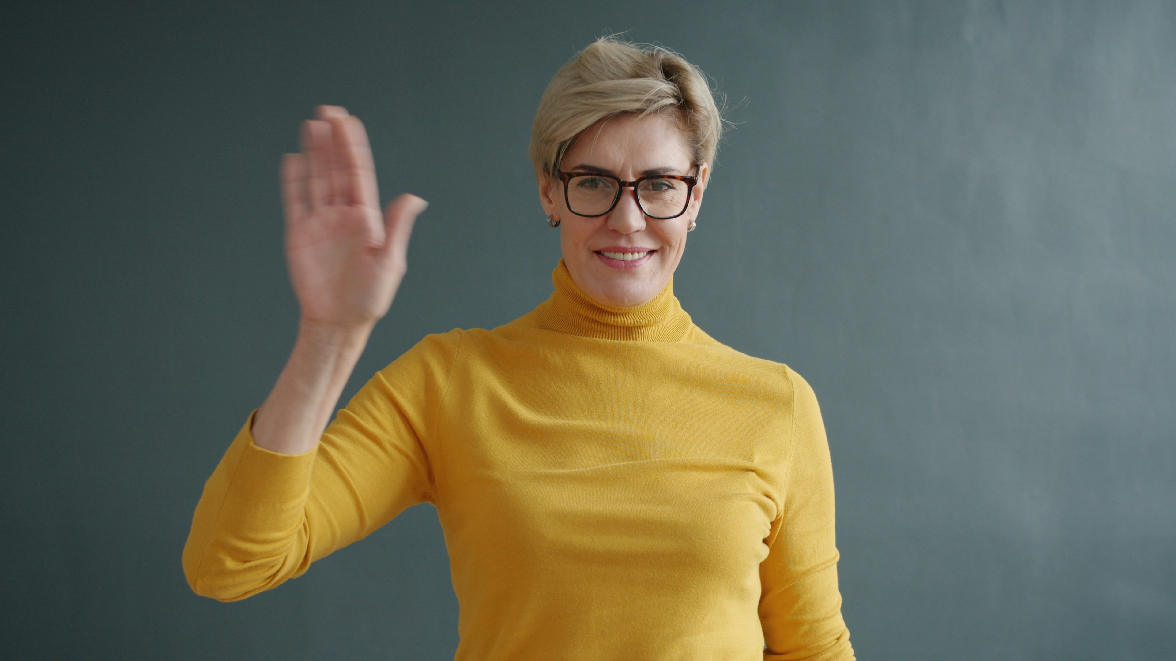 Eine glückliche Frau, die winkt | Quelle: Unsplash