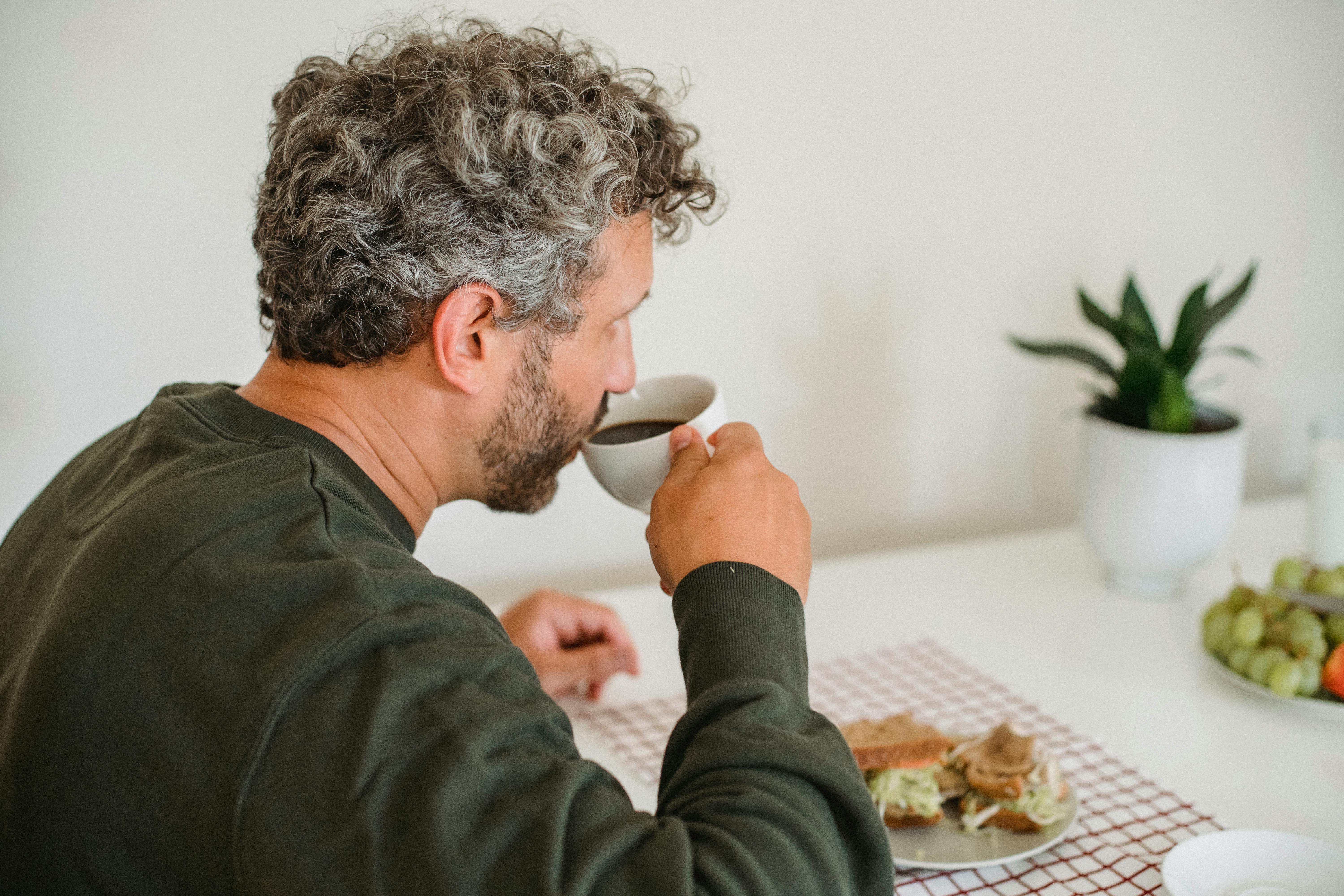 Ein Mann sitzt und trinkt Kaffee | Quelle: Pexels