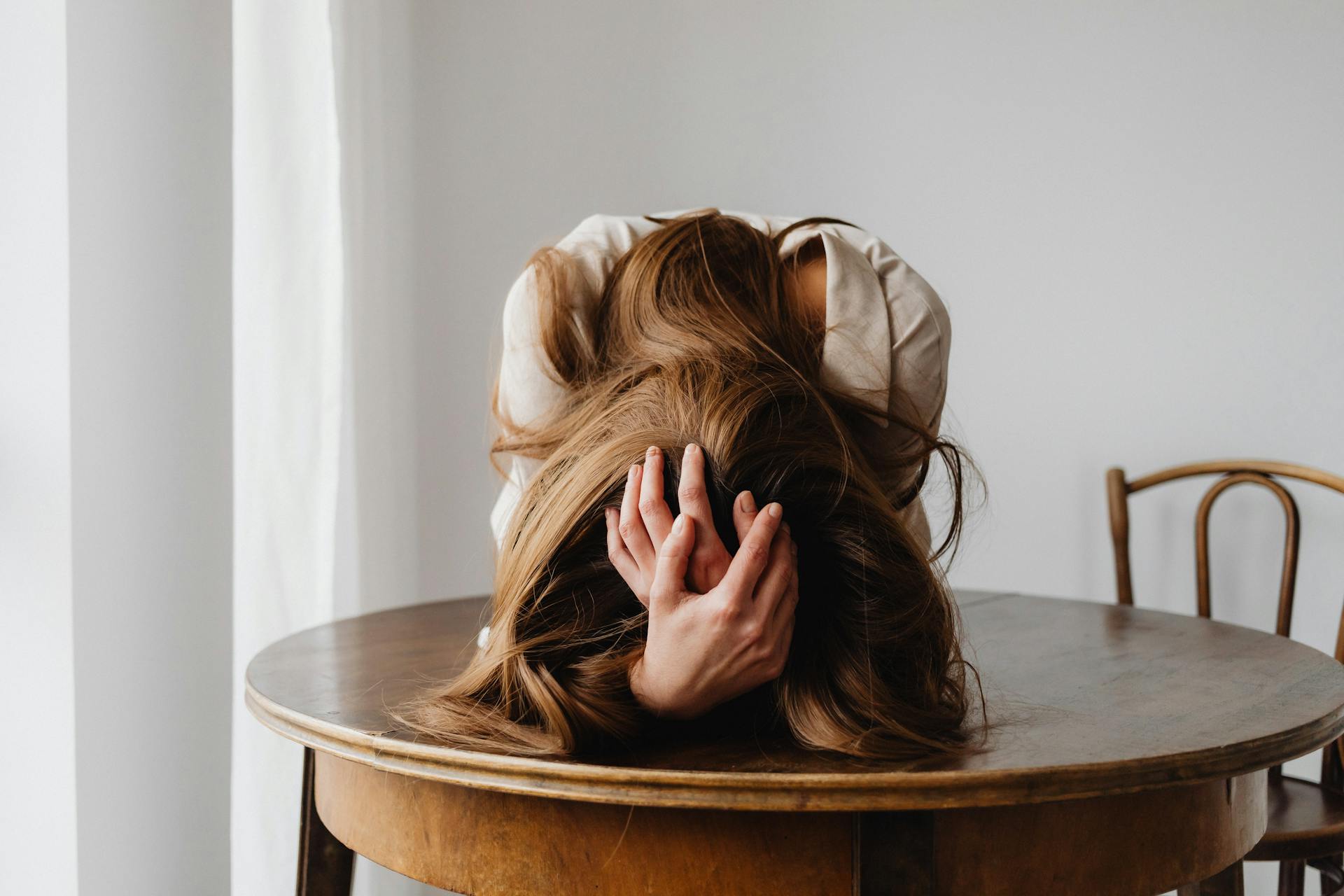Eine Frau, die ihren Kopf in ihren Händen hält | Quelle: Pexels