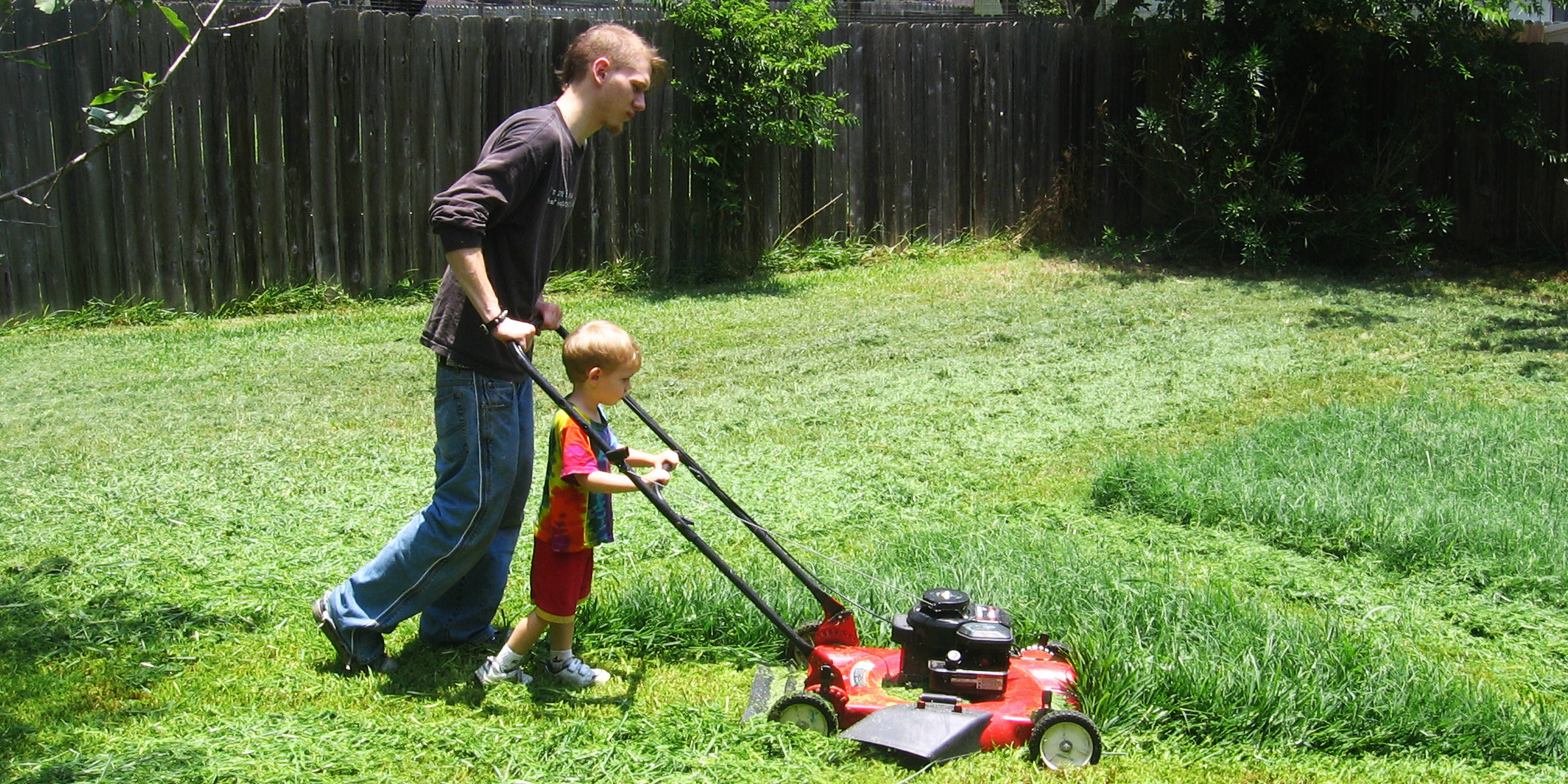 Ein Mann und sein Sohn mähen den Rasen | Quelle: Flickr