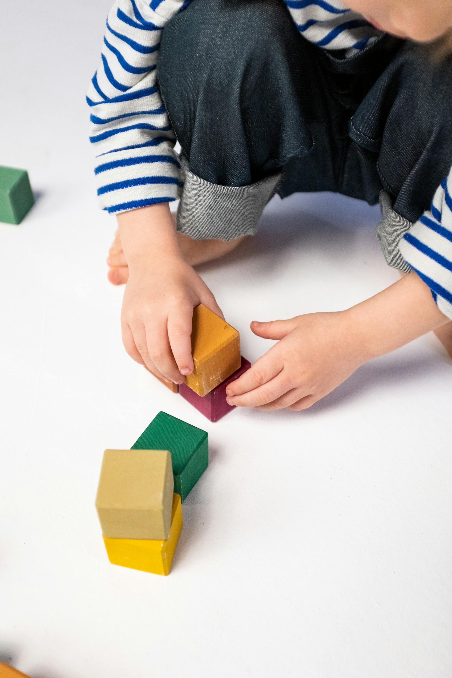 Eine Nahaufnahme eines Jungen, der mit Plastikklötzen spielt | Quelle: Pexels