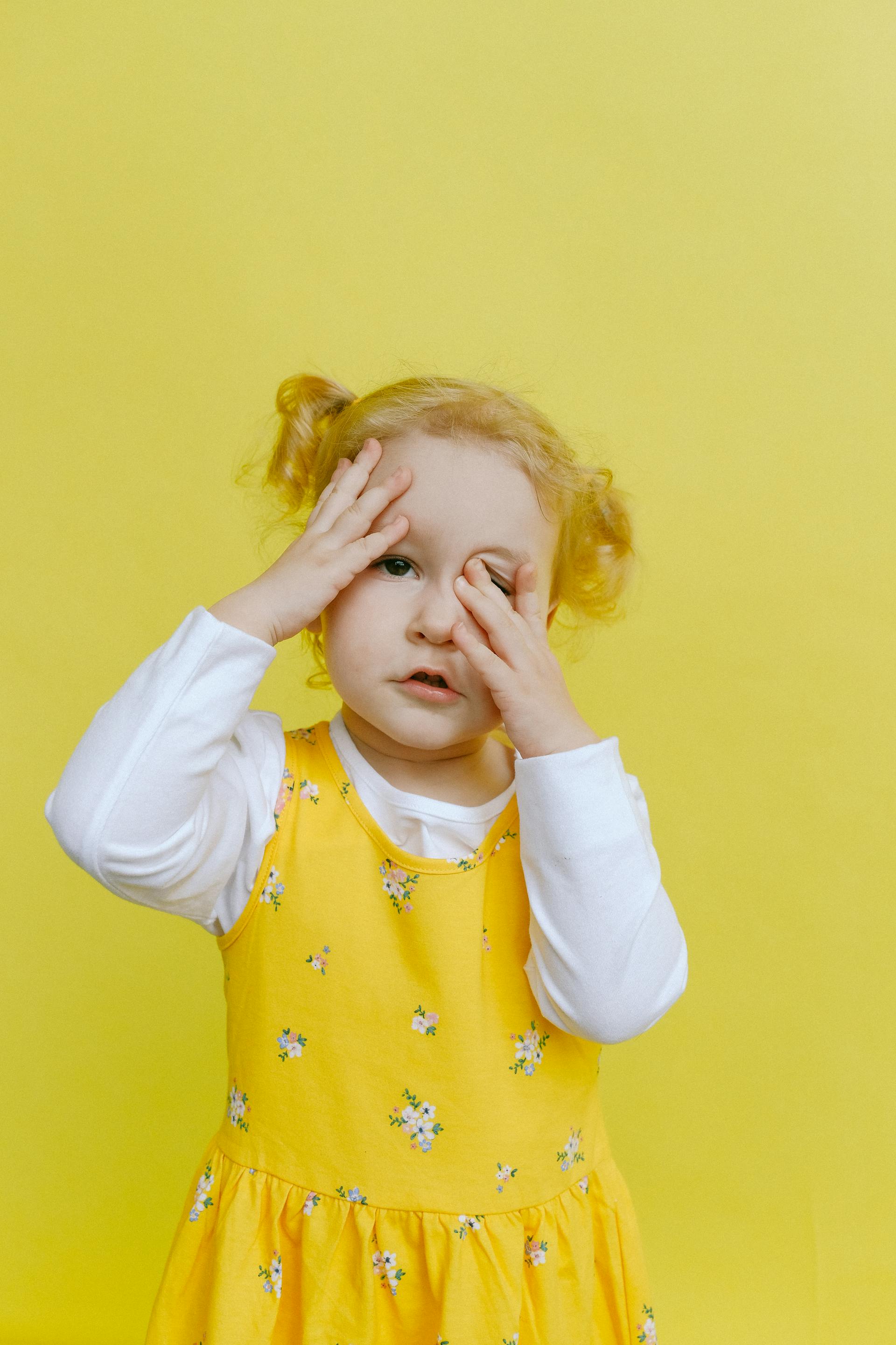 Ein kleines Mädchen, das sein Gesicht mit den Händen bedeckt | Quelle: Pexels