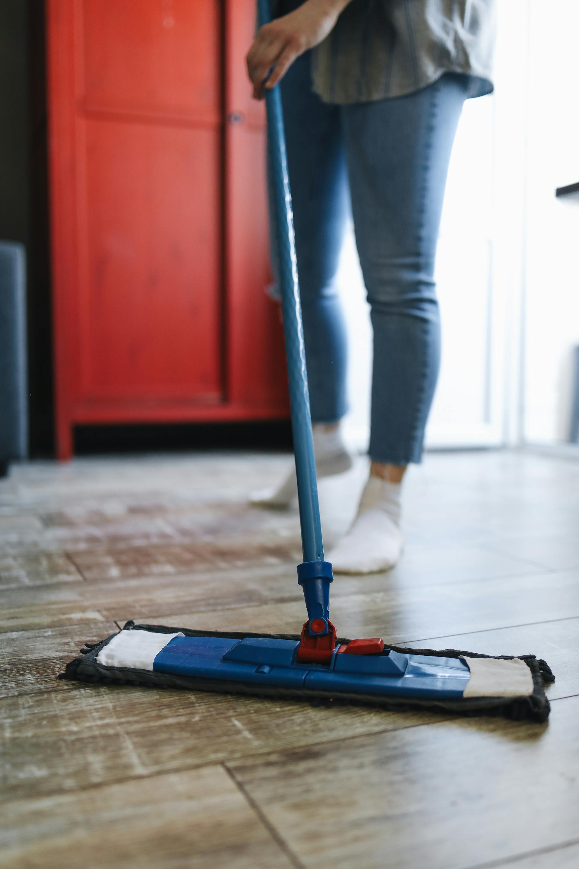 Eine Nahaufnahme einer Person, die den Boden mit einem Mopp reinigt | Quelle: Pexels