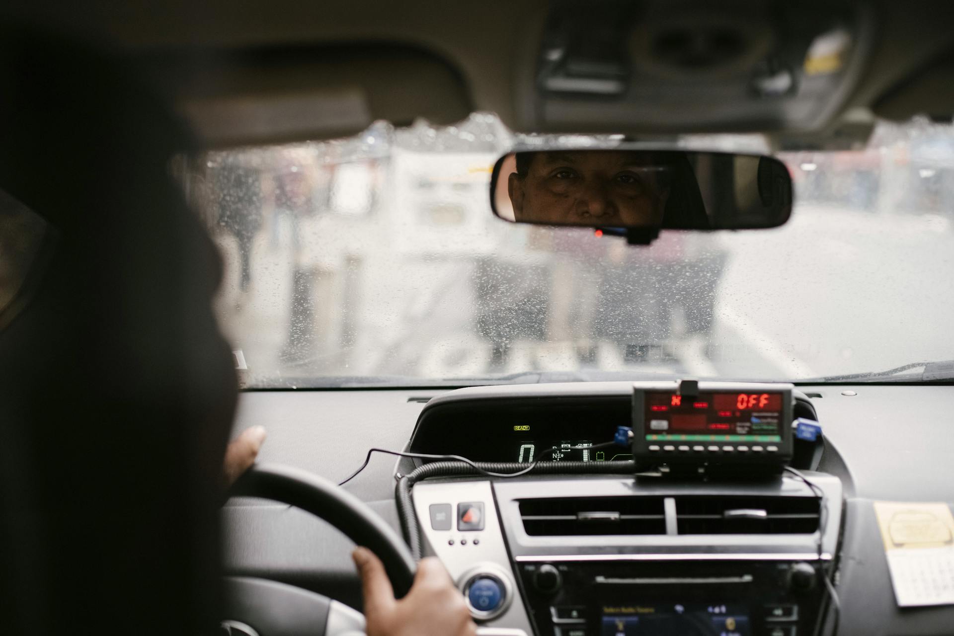 Ein Taxifahrer, der jemanden im Rückspiegel anschaut | Quelle: Pexels