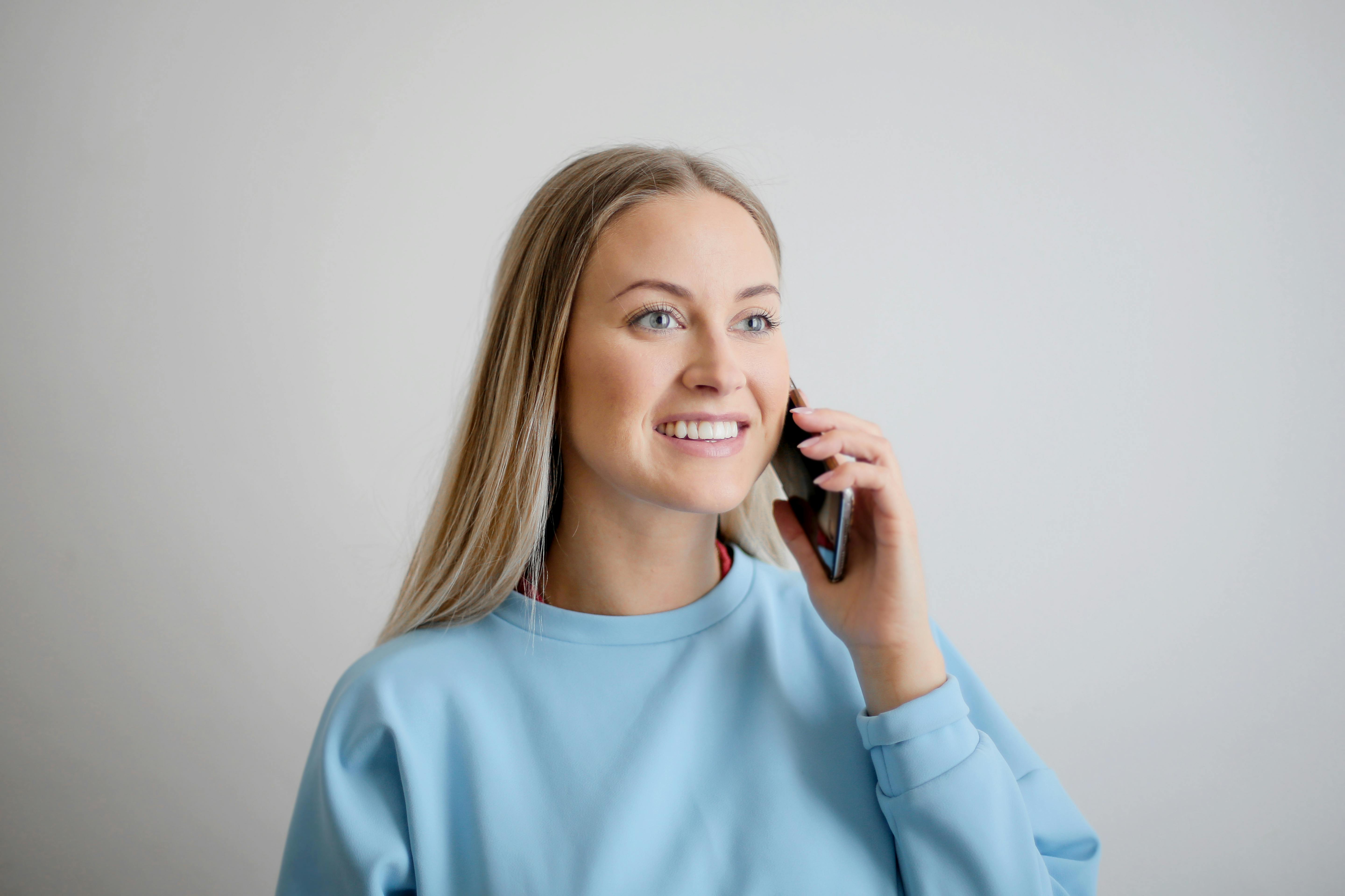 Eine lächelnde Frau, die am Telefon spricht | Quelle: Pexels
