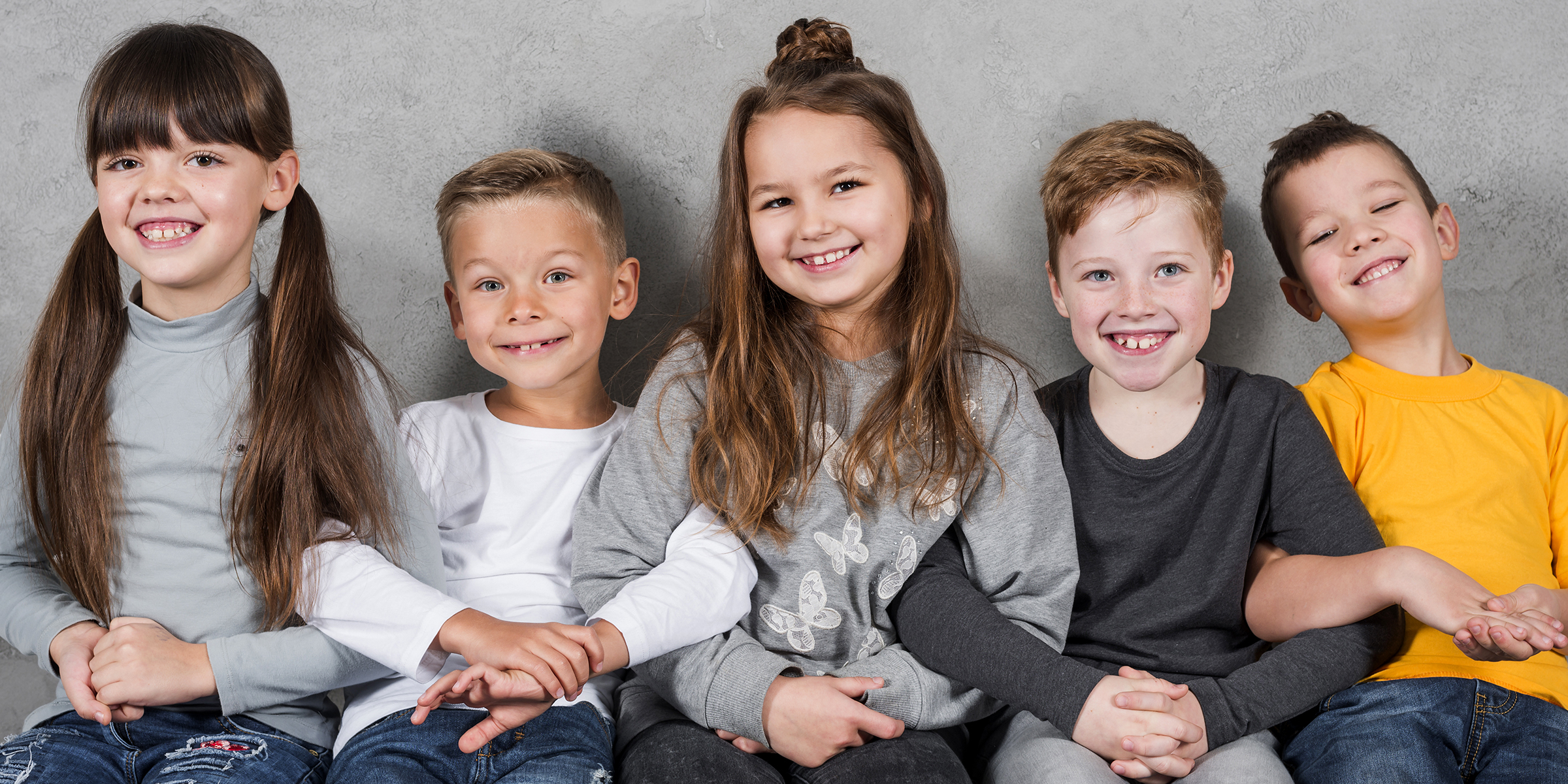 Fünf Kinder sitzen zusammen | Quelle: Freepik