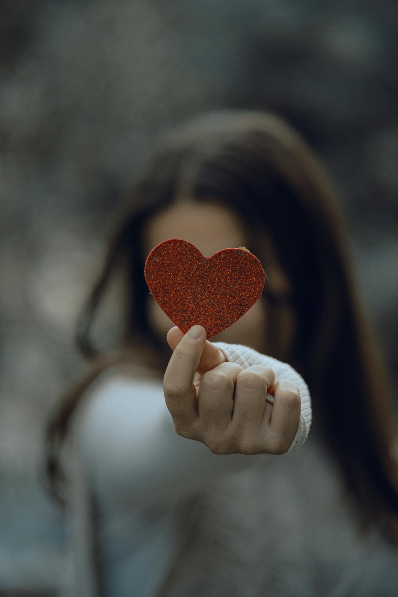Eine Frau, die ein glitzerndes Papierherz hält | Quelle: Pexels