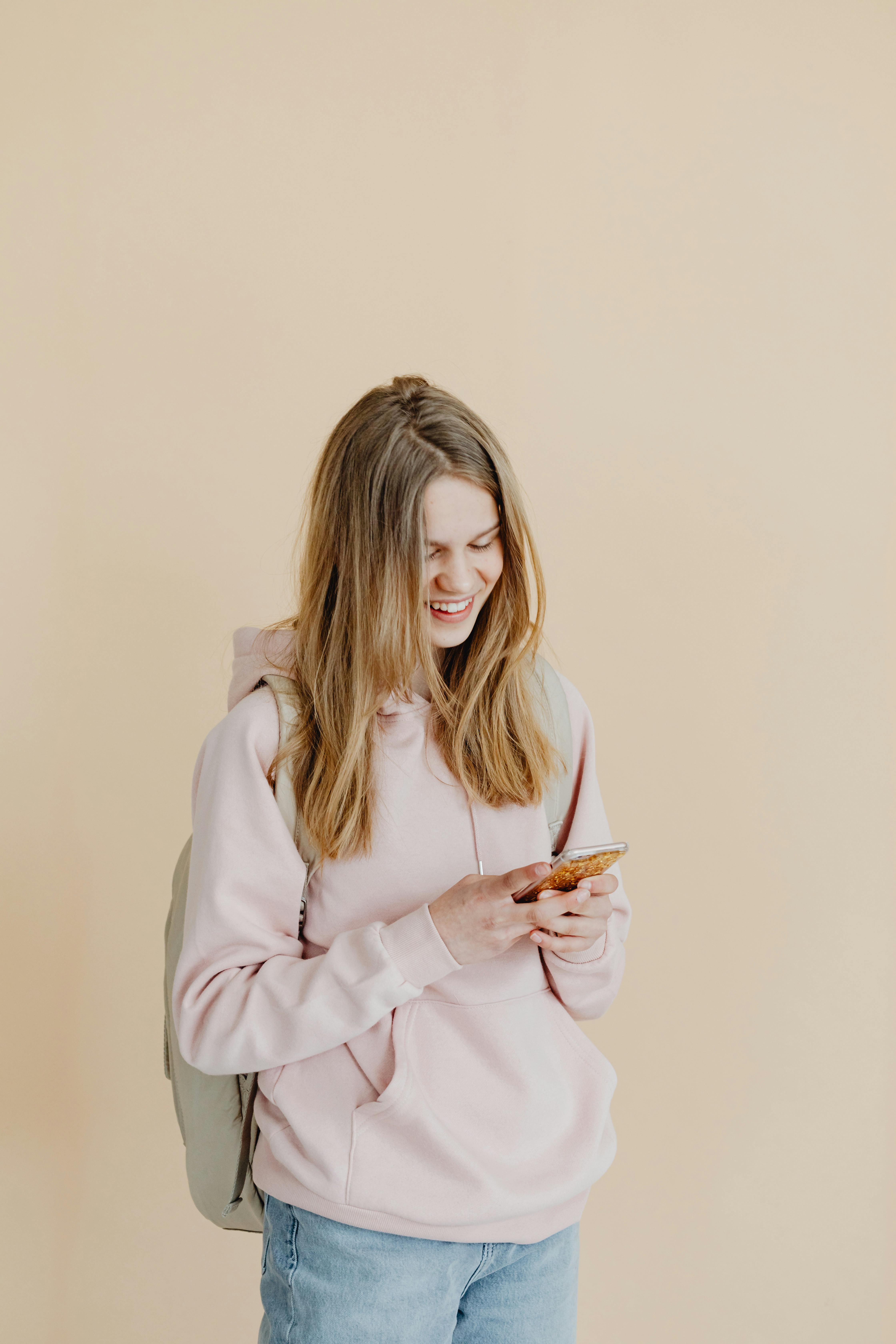 Ein glückliches Mädchen, das auf ihr Telefon schaut | Quelle: Pexels