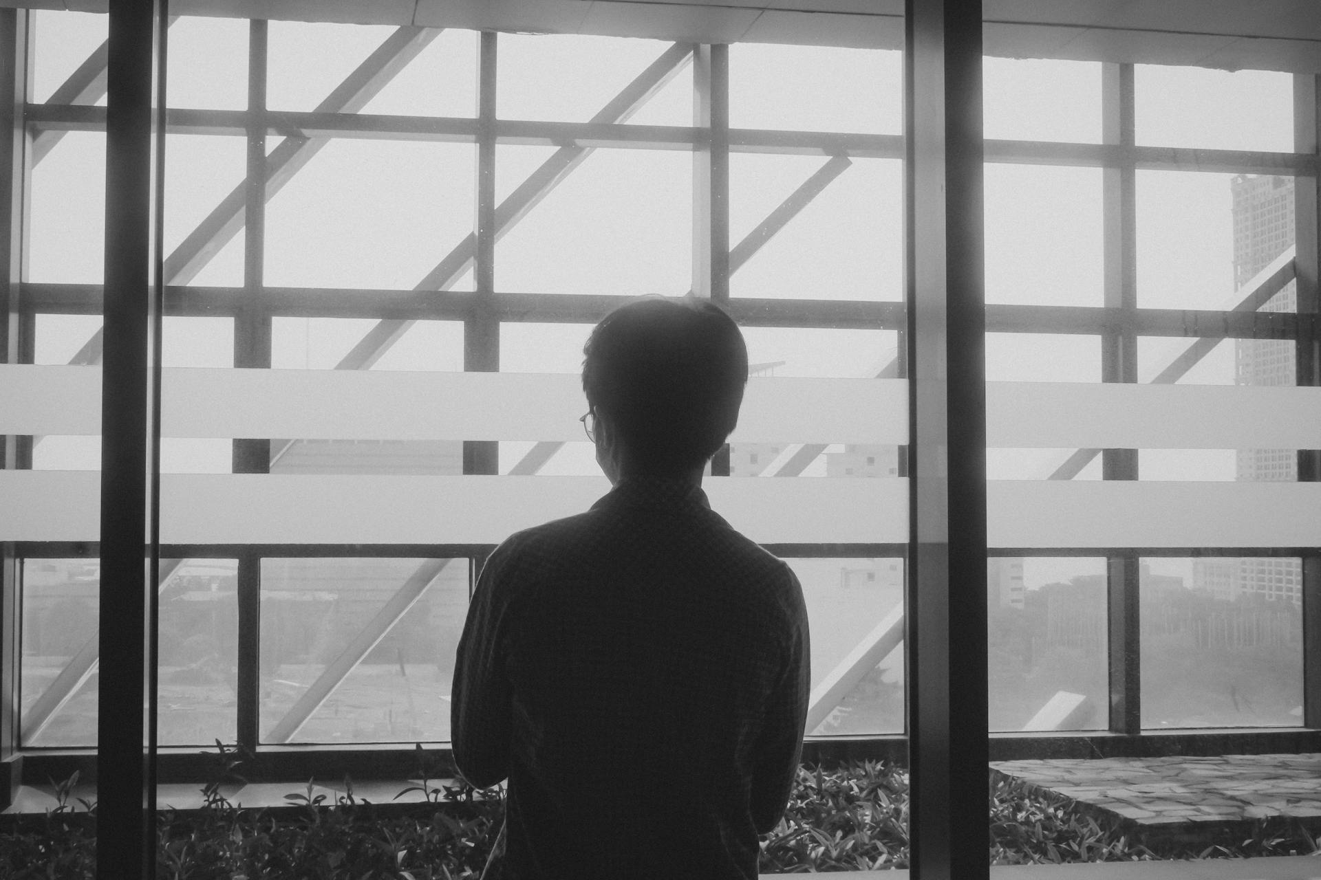 Ein Mann steht an einem Fenster | Quelle: Pexels