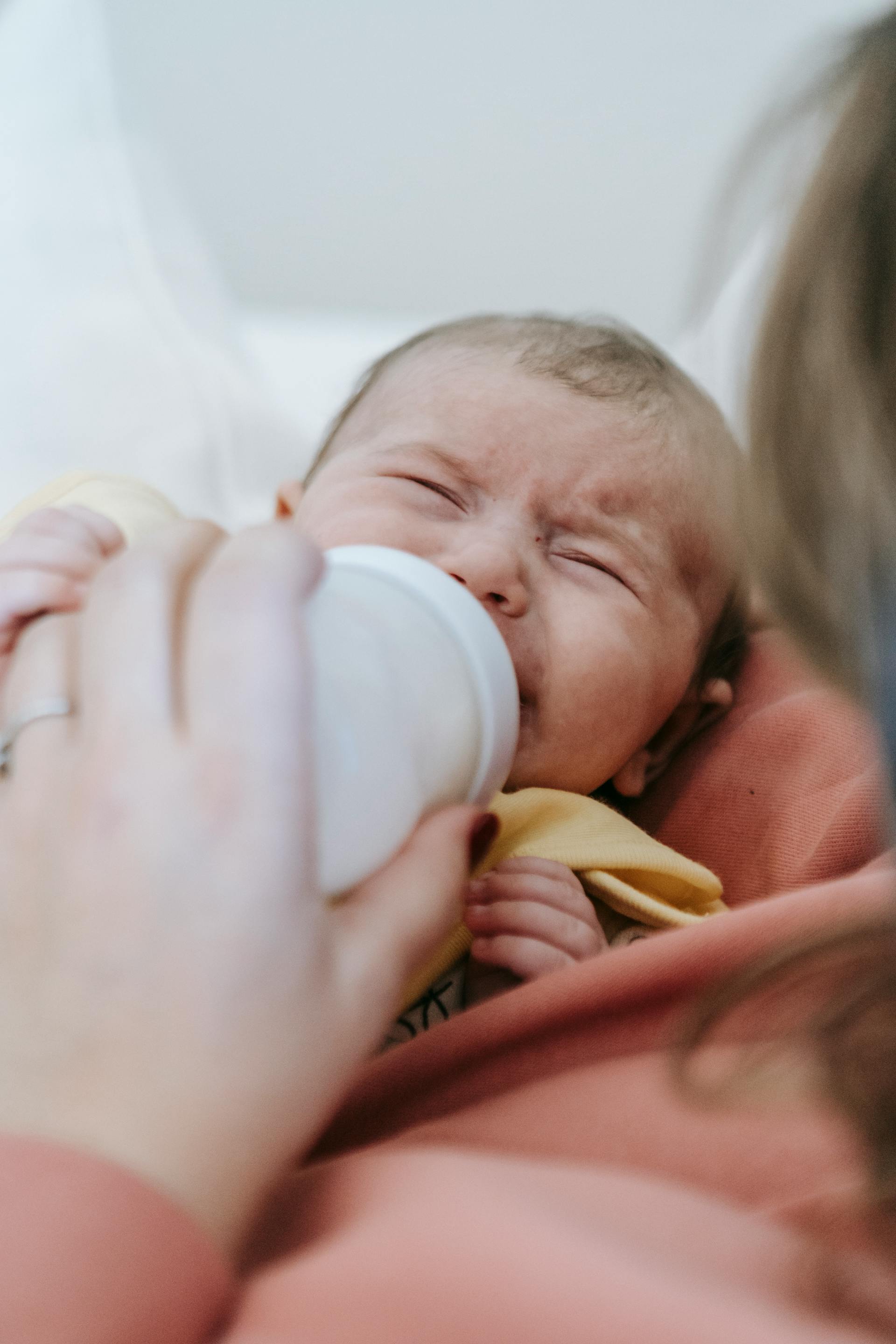 Eine Frau füttert ein weinendes Baby | Quelle: Pexels