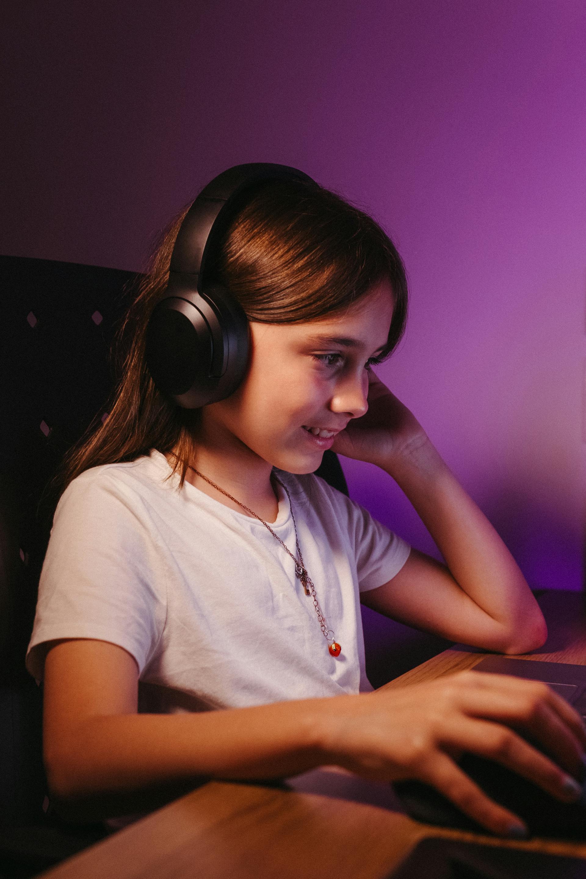 Ein Teenager-Mädchen mit einem Headset und einem Computer | Quelle: Pexels