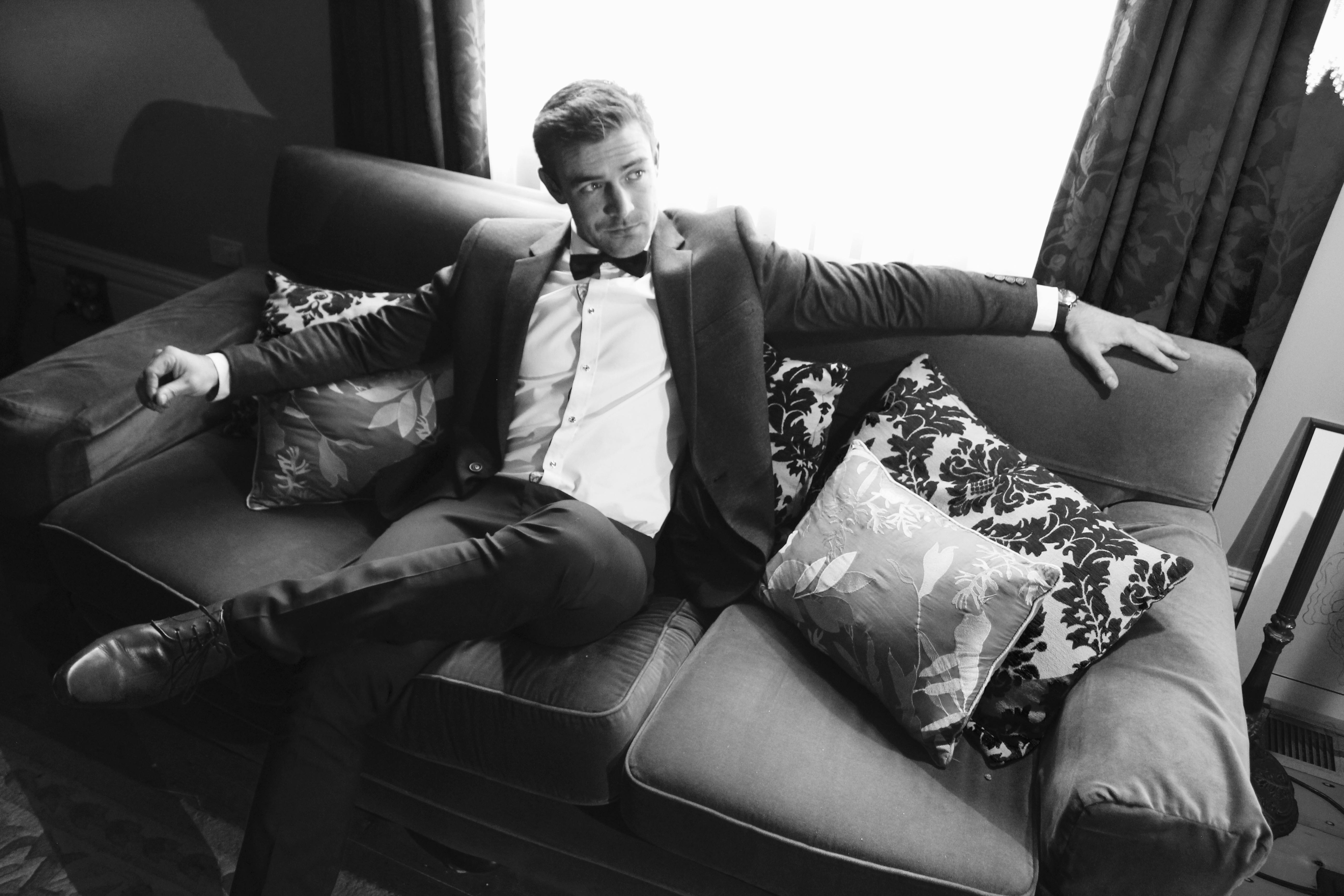 Mann im Anzug sitzt auf einem Sofa | Quelle: Pexels