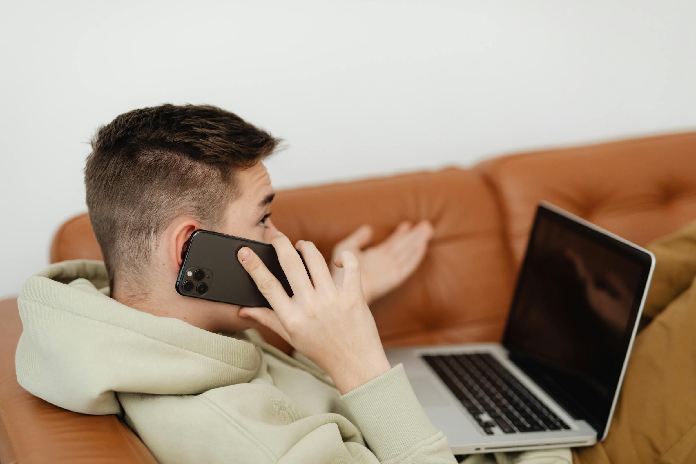 Ein Teenager-Junge auf einer Couch, der telefoniert | Quelle: Pexels