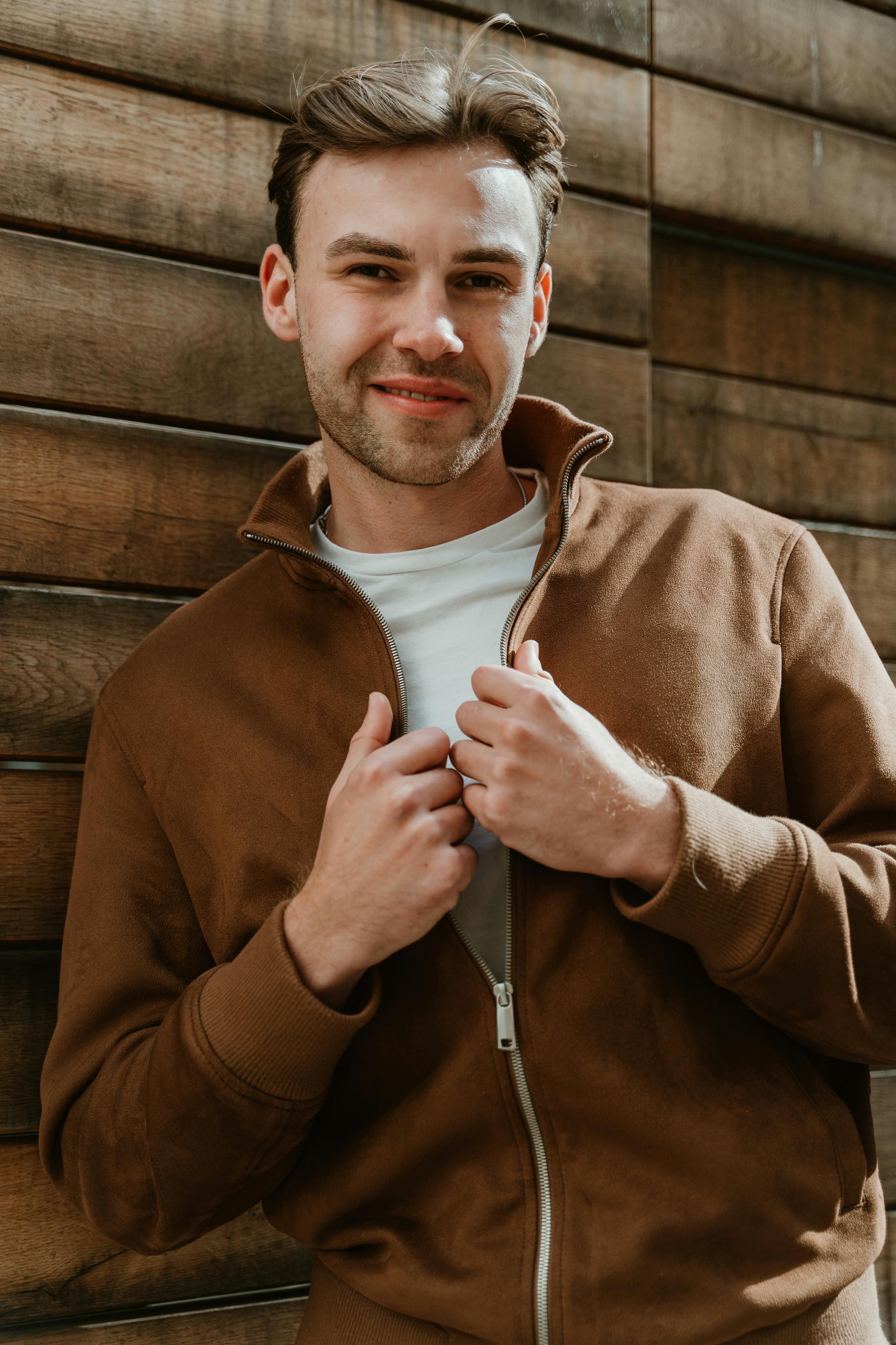 Ein lächelnder junger Mann mit einer braunen Jacke | Quelle: Pexels