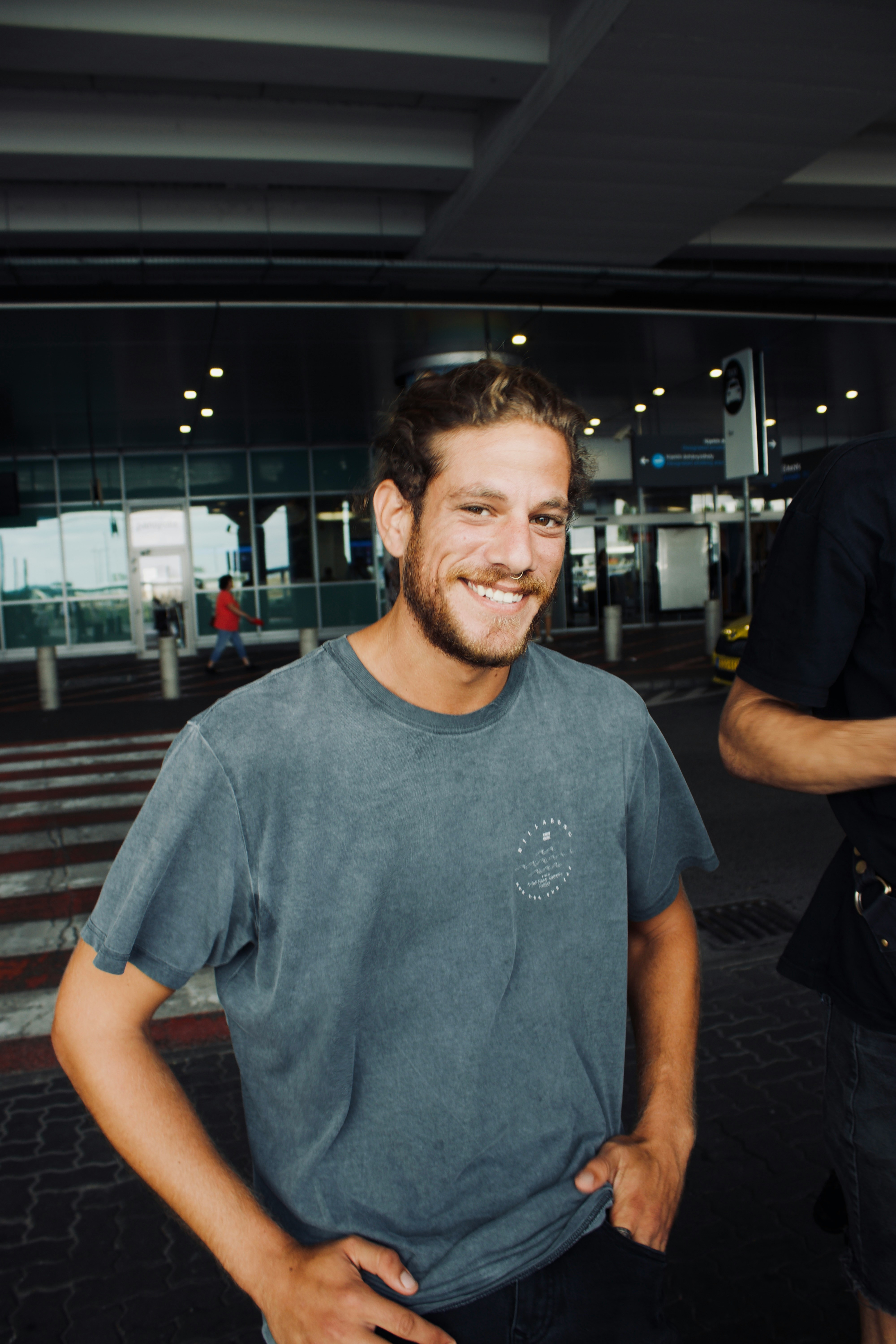 Ein lächelnder Mann vor einem Flughafen | Quelle: Unsplash