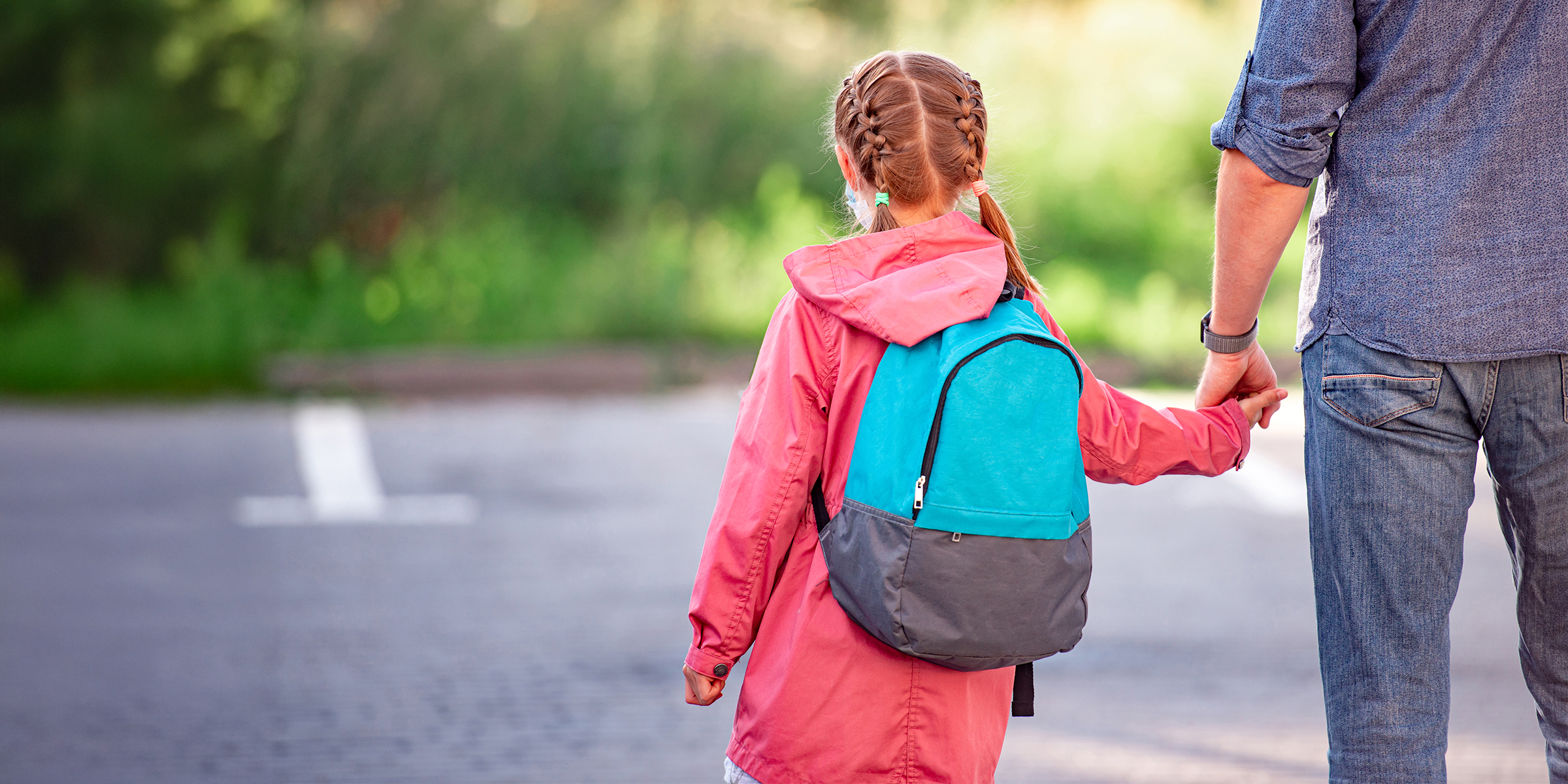 Ein Mädchen mit Rucksack geht mit ihrem Vater spazieren | Quelle: Shutterstock