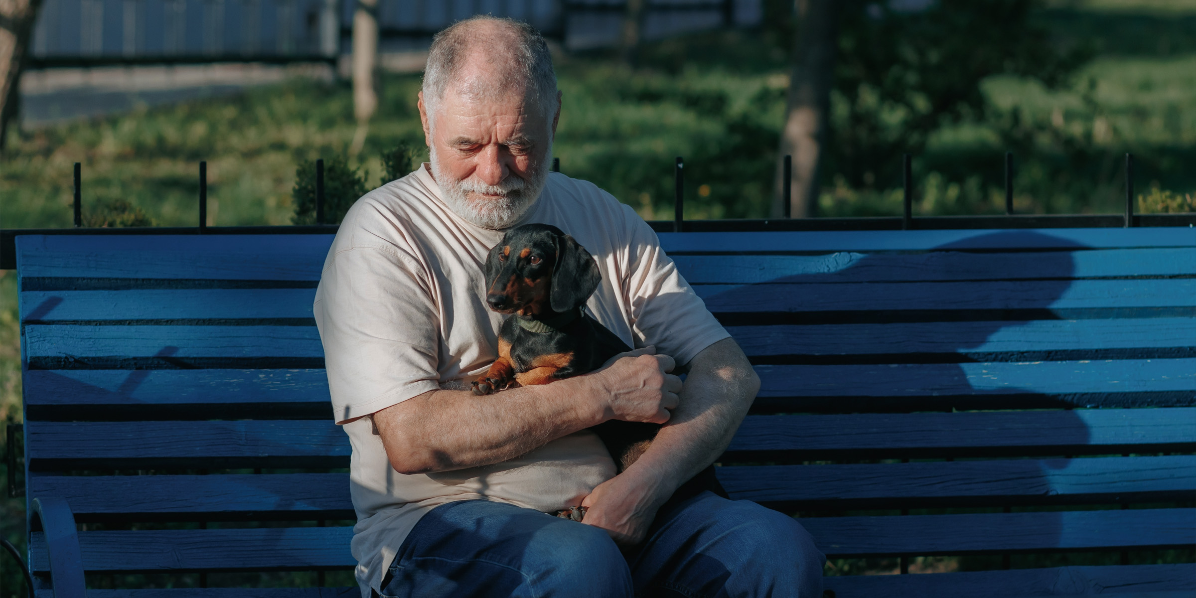 Ein sitzender Mann mit seinem Hund | Quelle: Shutterstock