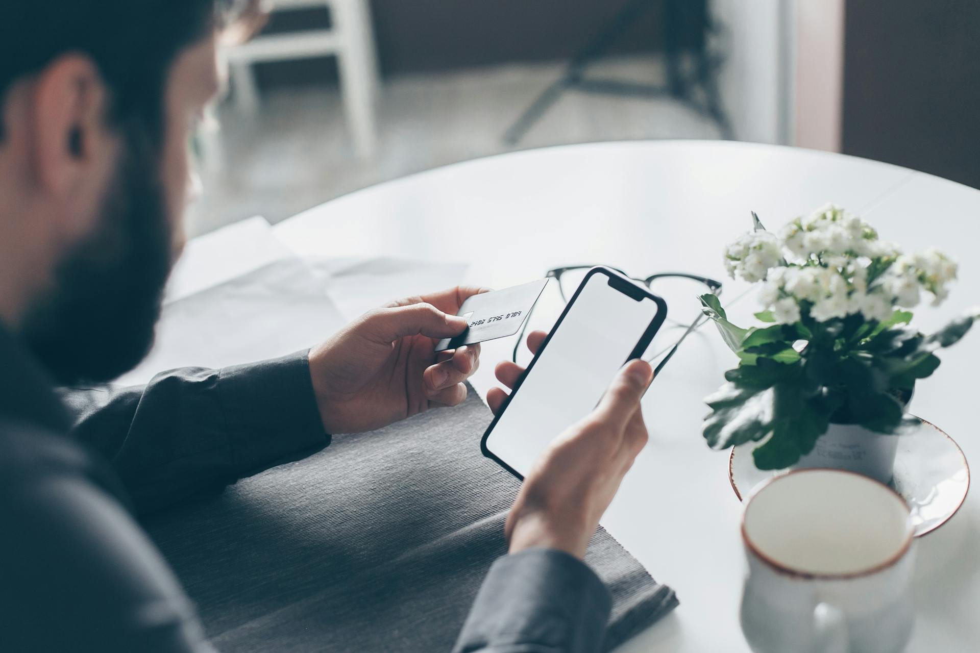 Ein Mann hält eine Bankkarte und ein Handy in der Hand | Quelle: Pexels