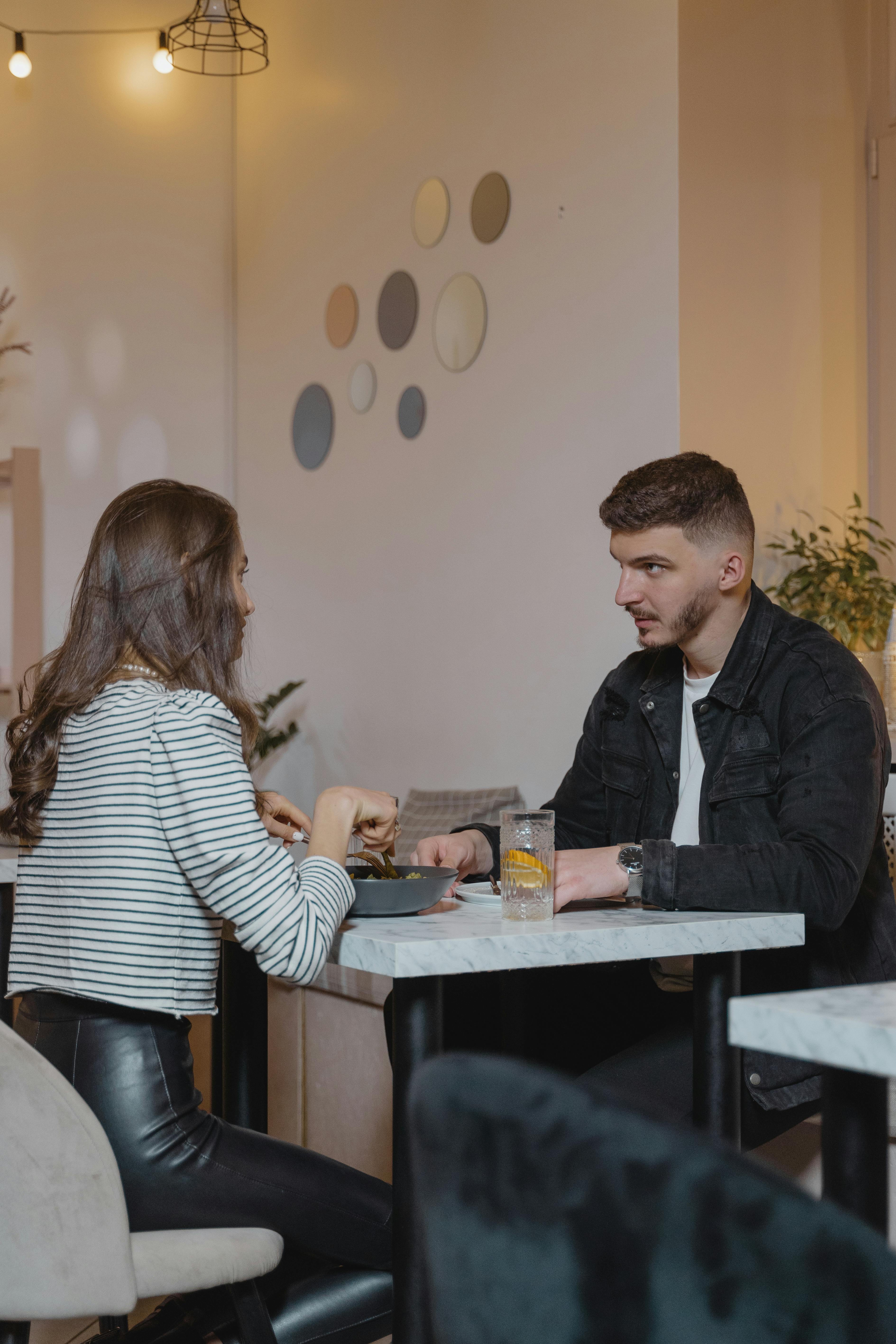 Ein Mann und eine Frau, die sich beim Essen unterhalten | Quelle: Pexels