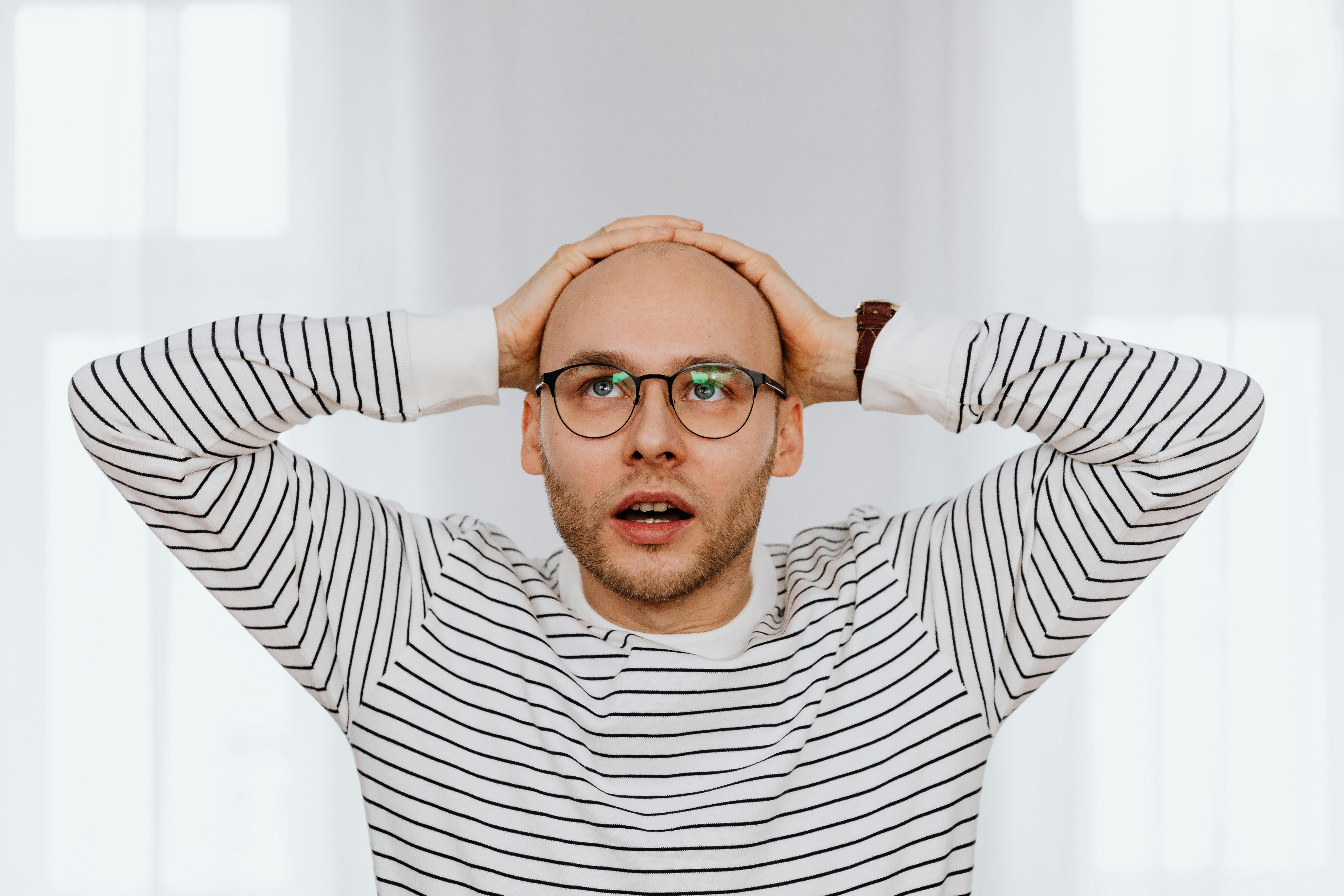 Ein Mann, der sitzt und seinen Kopf hält | Quelle: Pexels