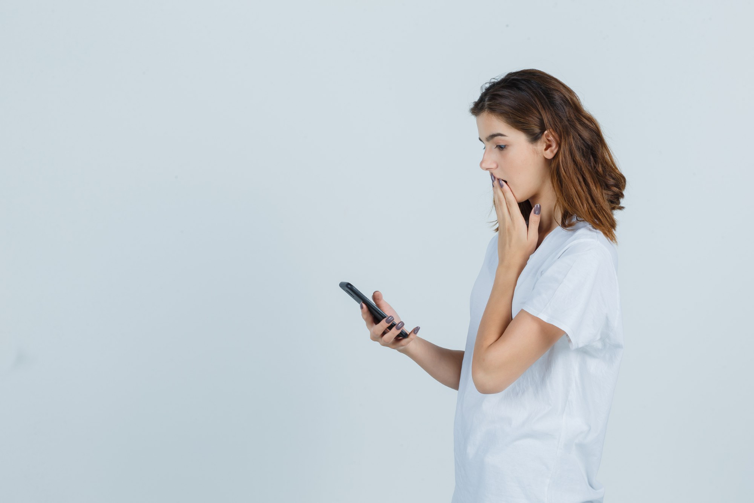 Eine besorgte Frau starrt auf ihr Telefon | Quelle: Freepik