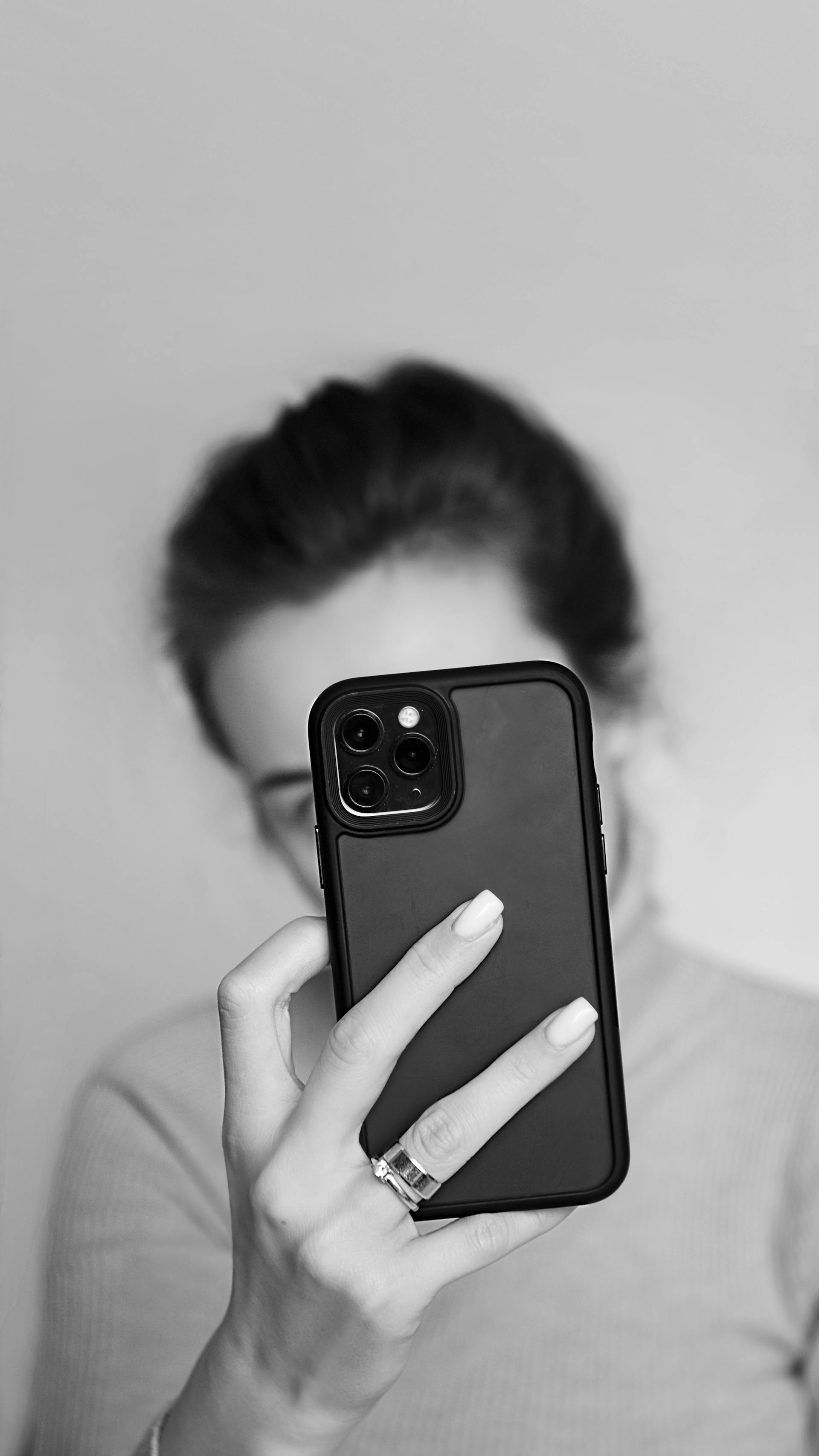Graustufenaufnahme einer Frau, die ihr Telefon hält | Quelle: Pexels