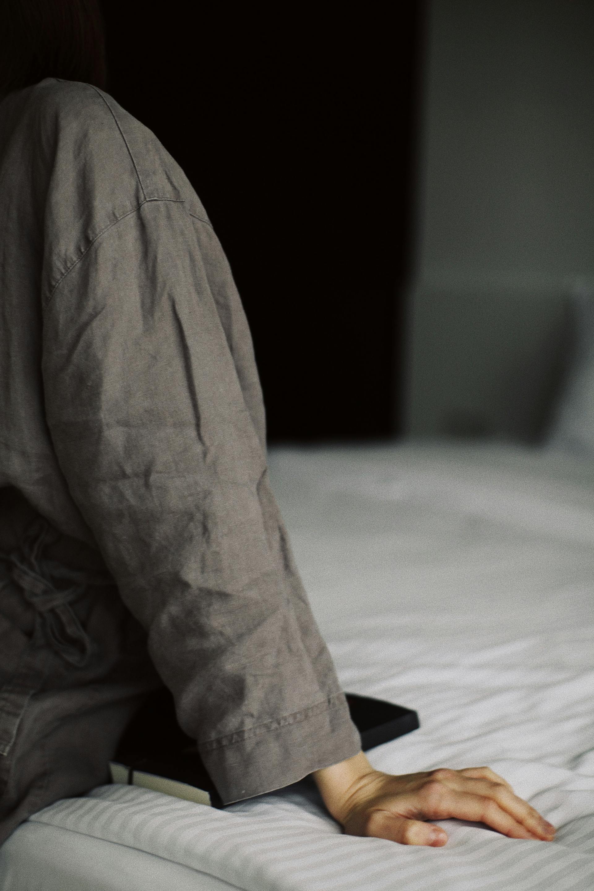 Nahaufnahme einer Frau, die auf dem Bett sitzt | Quelle: Pexels