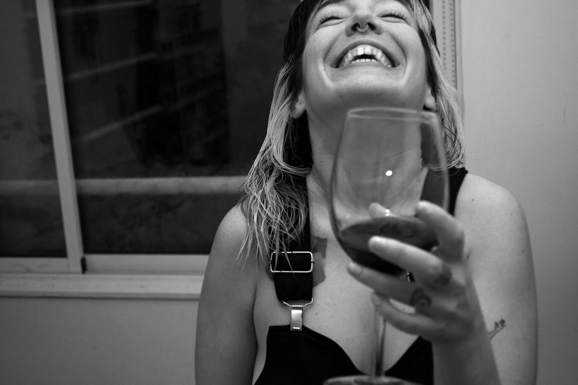 Eine glückliche Frau beim Anstoßen | Quelle: Pexels