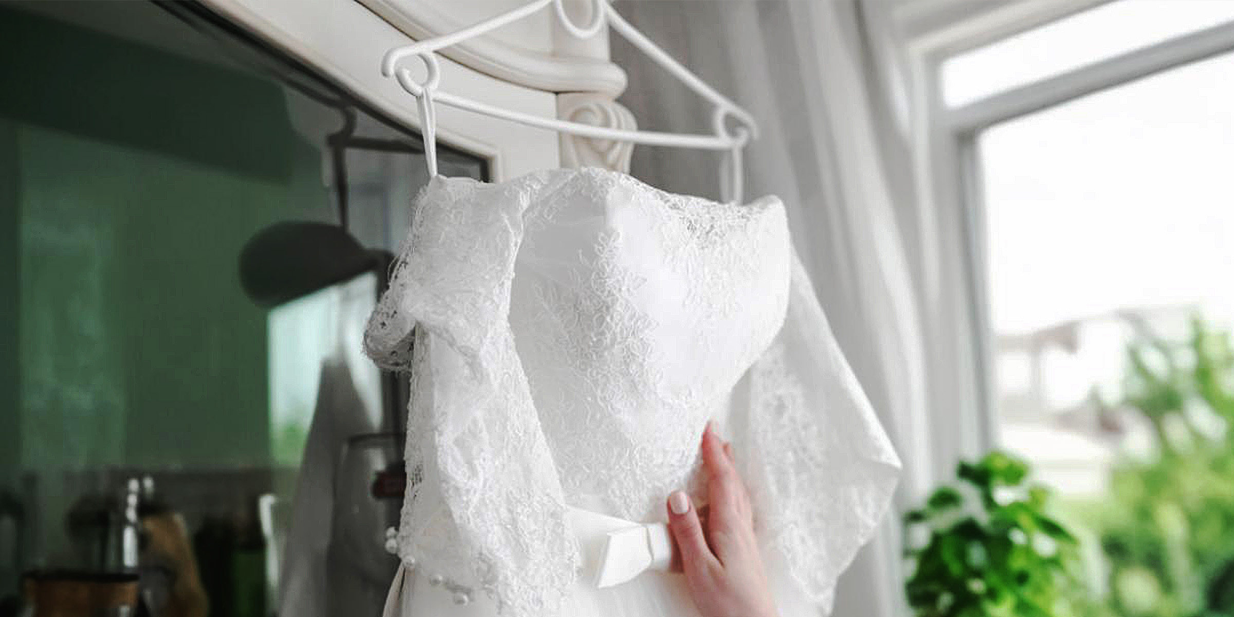 Eine Frau, die ein Brautkleid anfasst | Quelle: Freepik