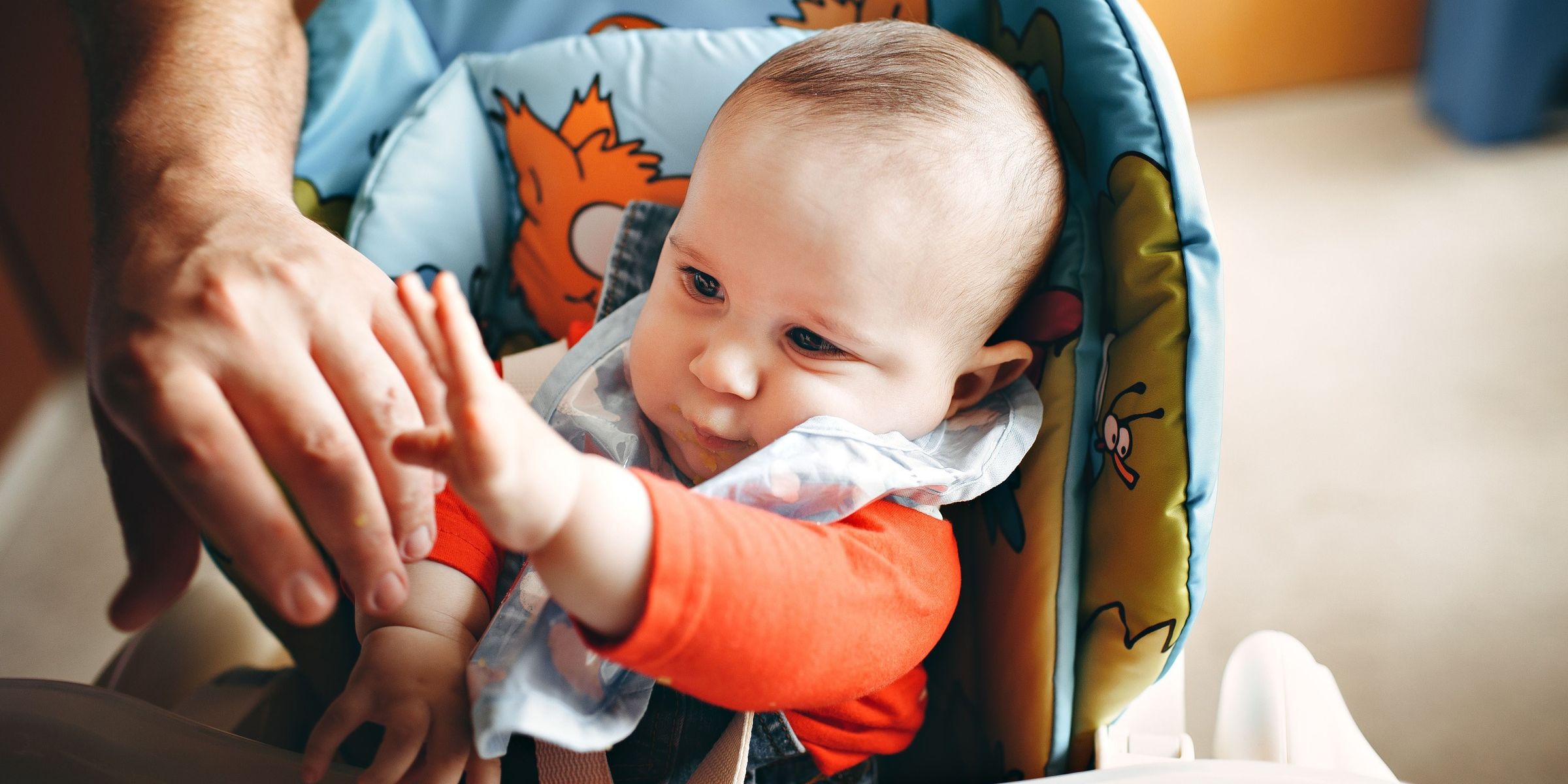 Eine Nahaufnahme eines Babys. Ein süßes Baby im Hochstuhl, das nach seinen Eltern greift | Quelle: Pexels