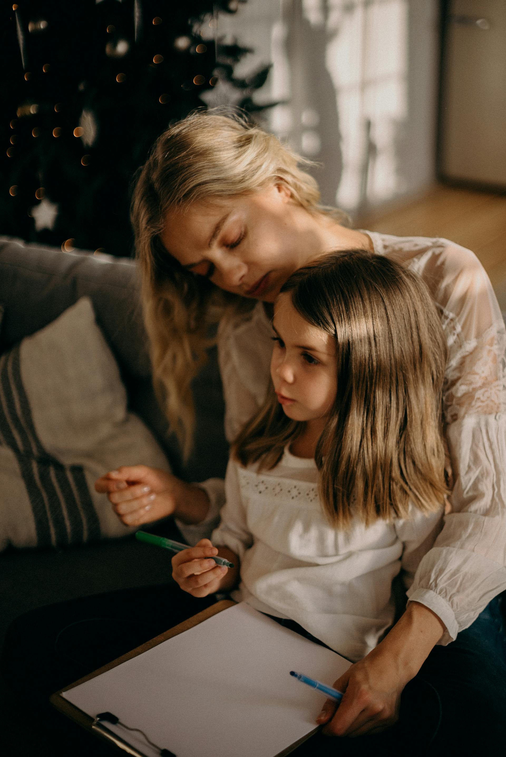 Eine Mutter sitzt mit ihrer kleinen Tochter zusammen | Quelle: Pexels