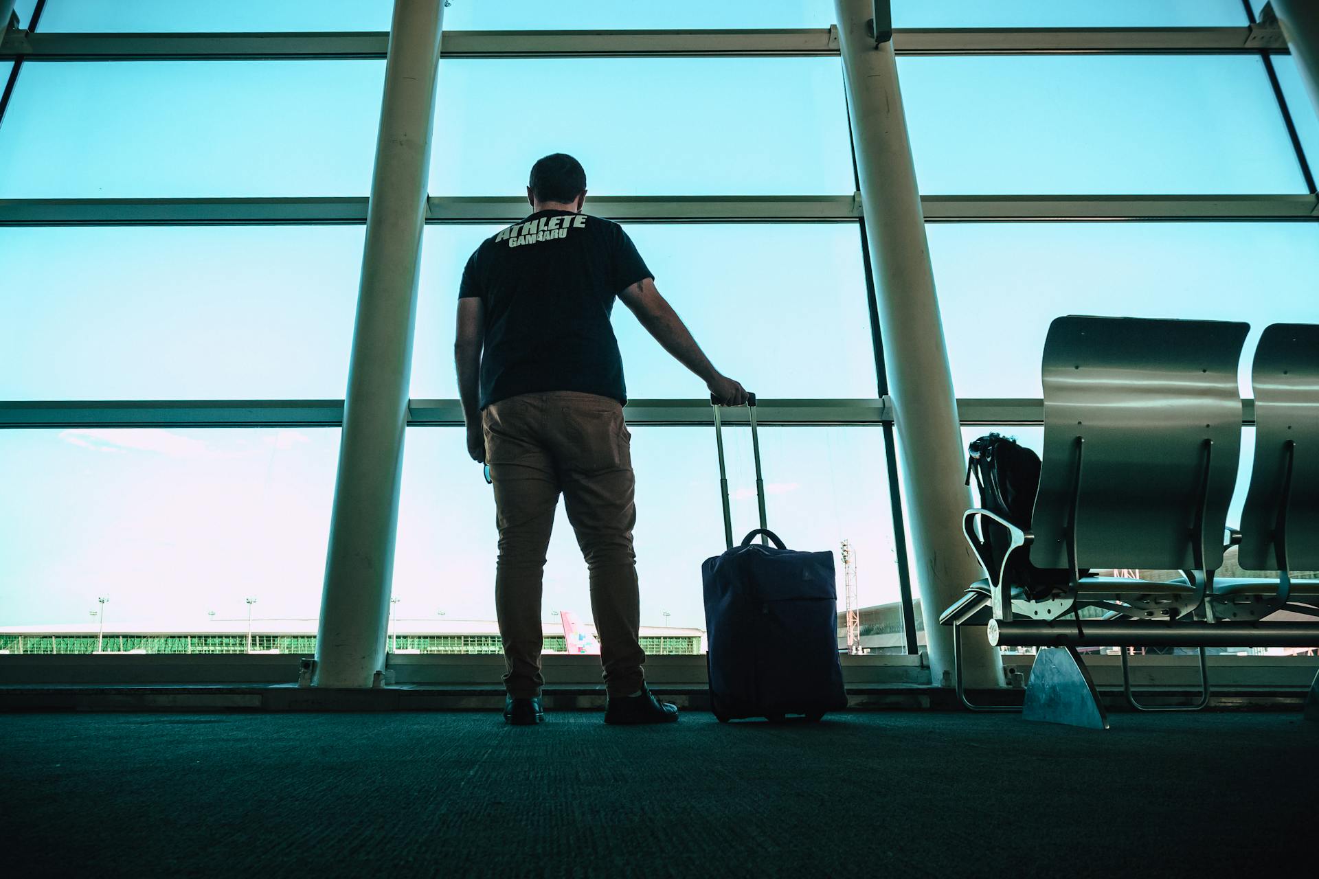 Ein Mann steht in einer Wartehalle am Flughafen | Quelle: Pexels