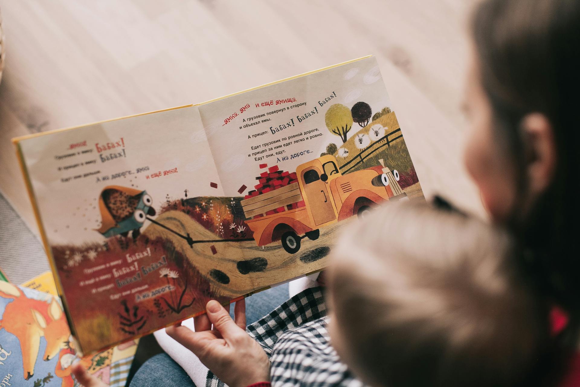 Eine Frau liest einem Kleinkind ein Buch vor | Quelle: Pexels