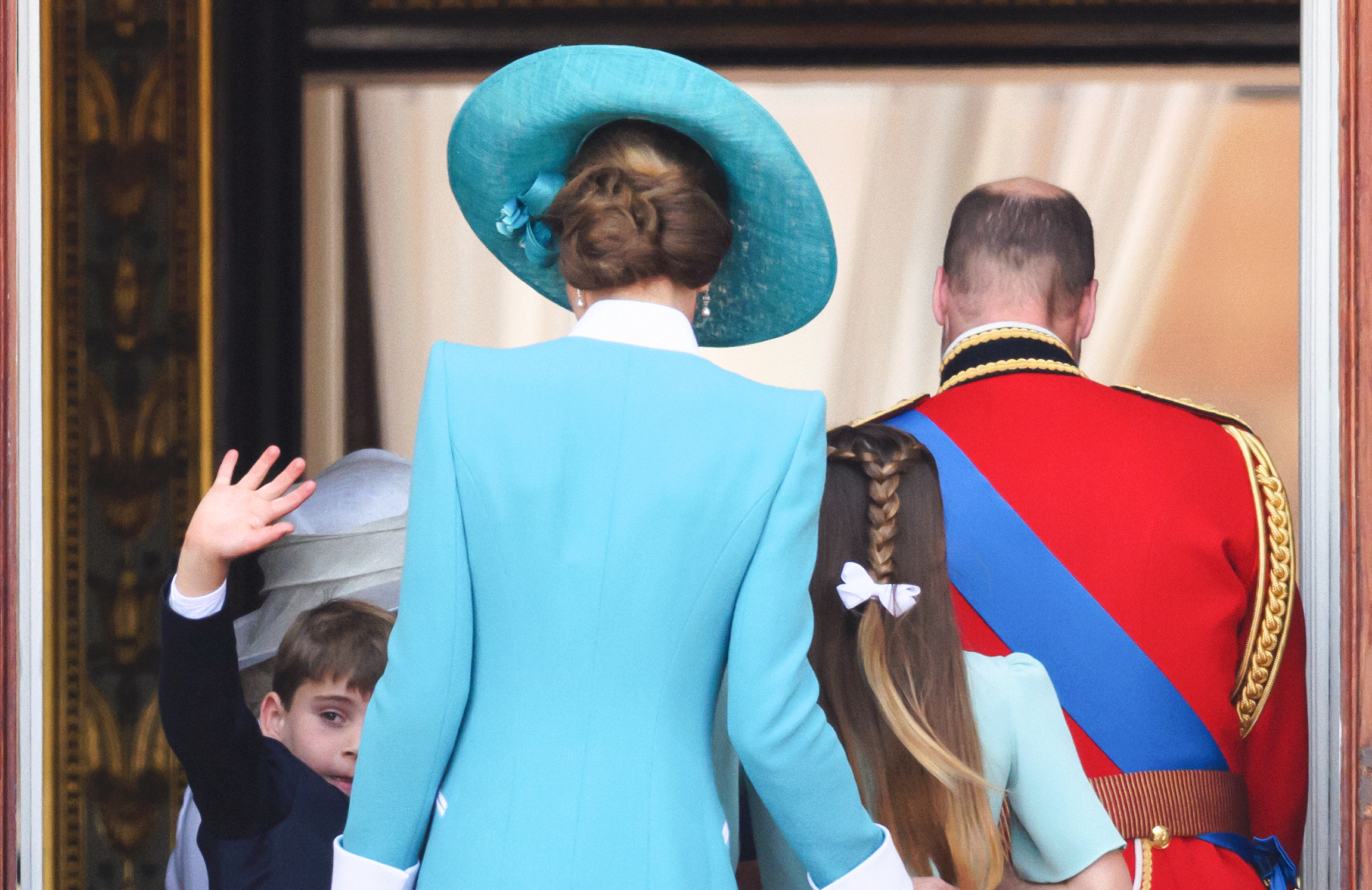 Prinz William, Prinzessin Catherine und ihre Kinder - Prinz George, Prinzessin Charlotte und Prinz Louis - sind beim Trooping the Colour 2025 von hinten zu sehen. Ihre Silhouetten werden von formeller Kleidung und königlicher Haltung umrahmt und symbolisieren die Einheit und das dauerhafte Erbe des Königshauses.