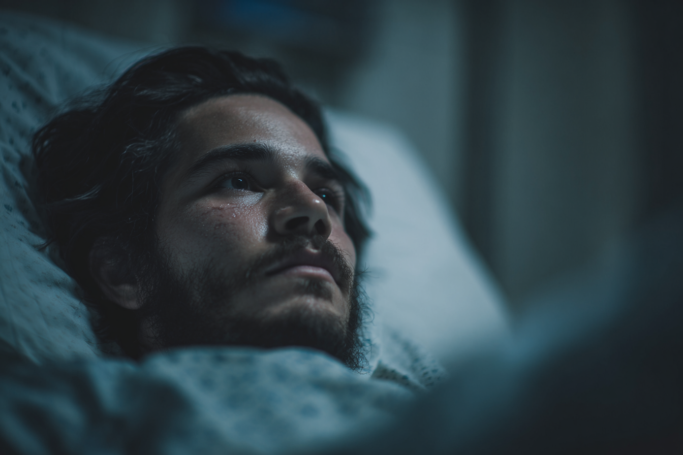 Ein Mann in einem Krankenhausbett, der klagend auf jemanden starrt | Quelle: Midjourney