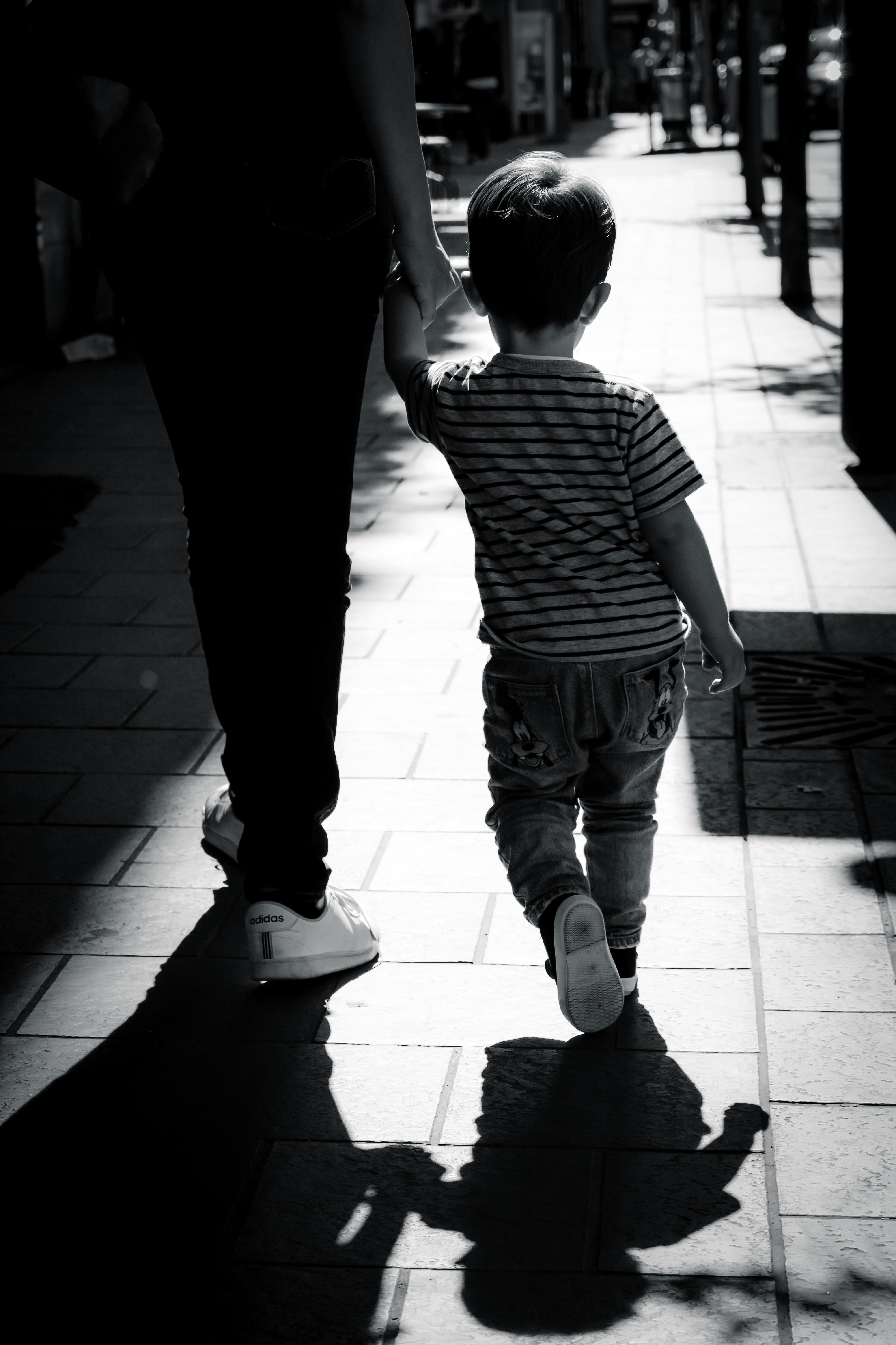 Eine Frau geht mit einem Jungen spazieren | Quelle: Unsplash
