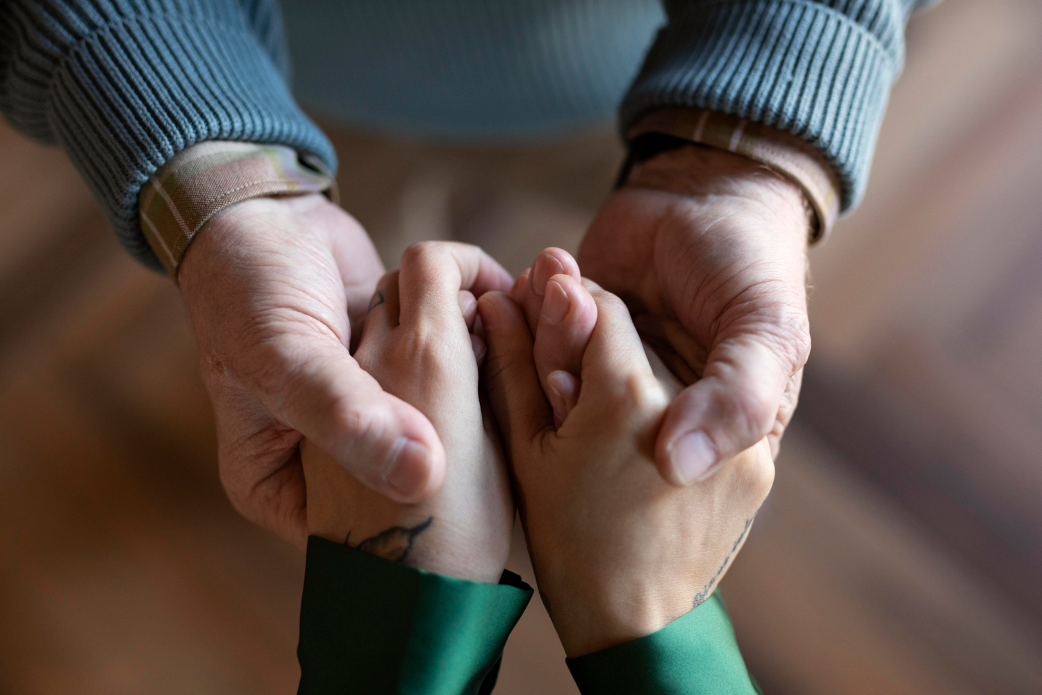 Eine junge Frau hält die Hände eines älteren Mannes | Quelle: Freepik