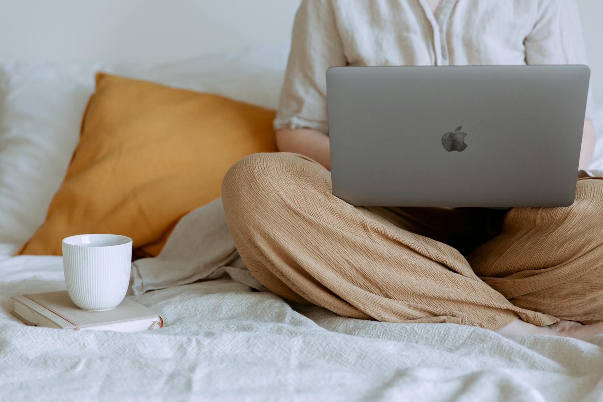 Eine Nahaufnahme einer Frau, die im Bett sitzend an ihrem Laptop arbeitet | Quelle: Pexels