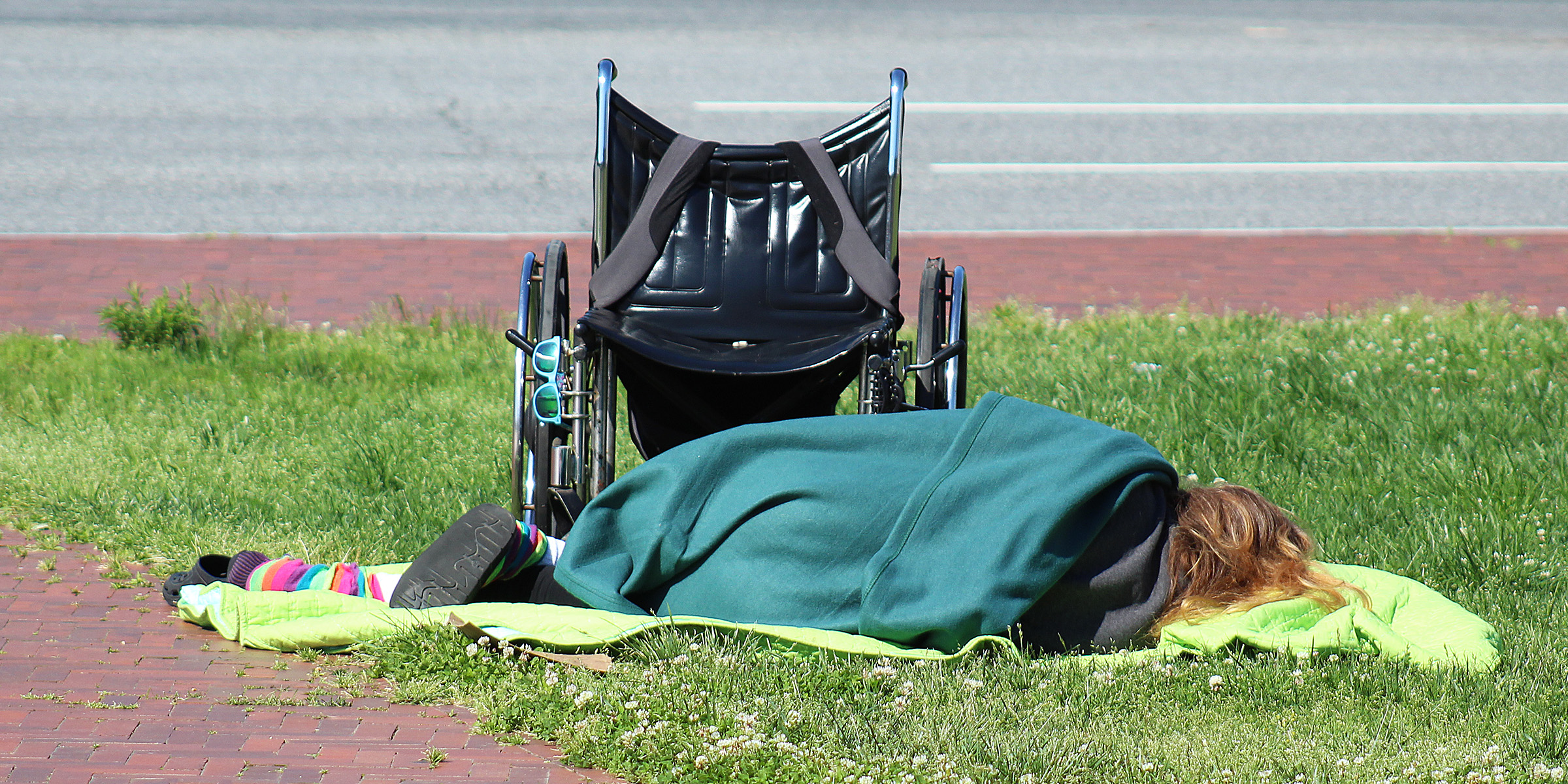 Eine obdachlose Person, die auf dem Boden schläft | Quelle: Flickr