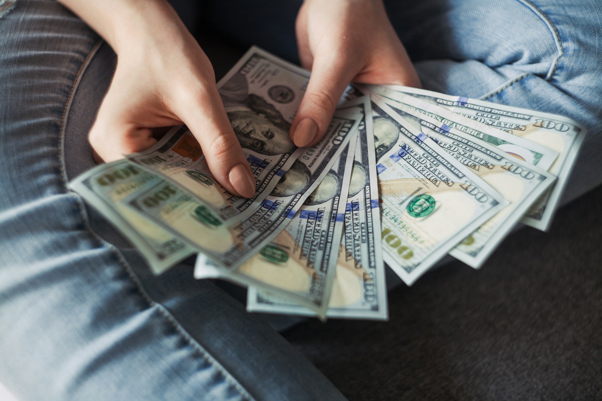 Eine junge Frau mit Dollarscheinen in der Hand | Quelle: Unsplash