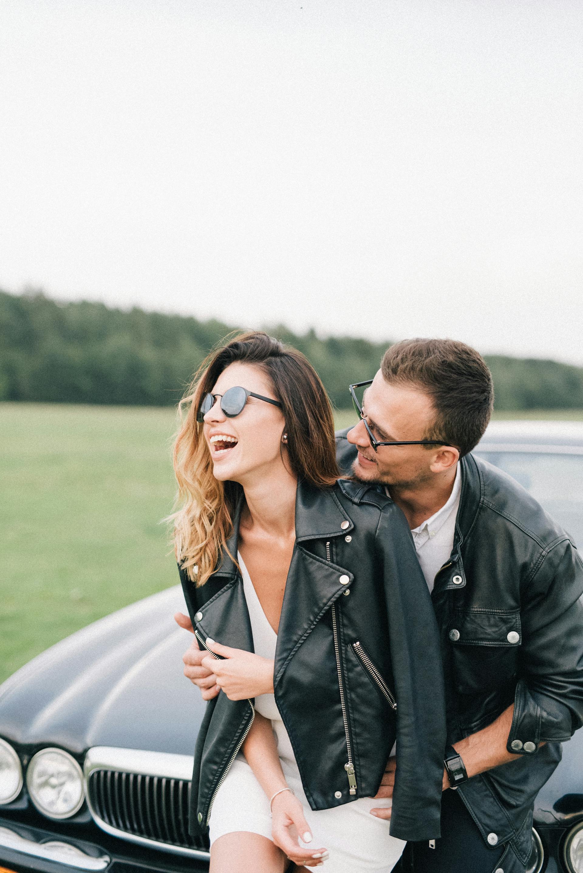 Ein glückliches Paar steht vor einem Auto | Quelle: Pexels