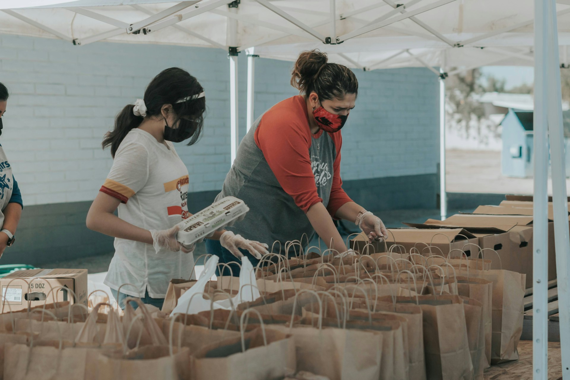 Freiwillige packen gespendete Gegenstände in Tüten | Quelle: Unsplash