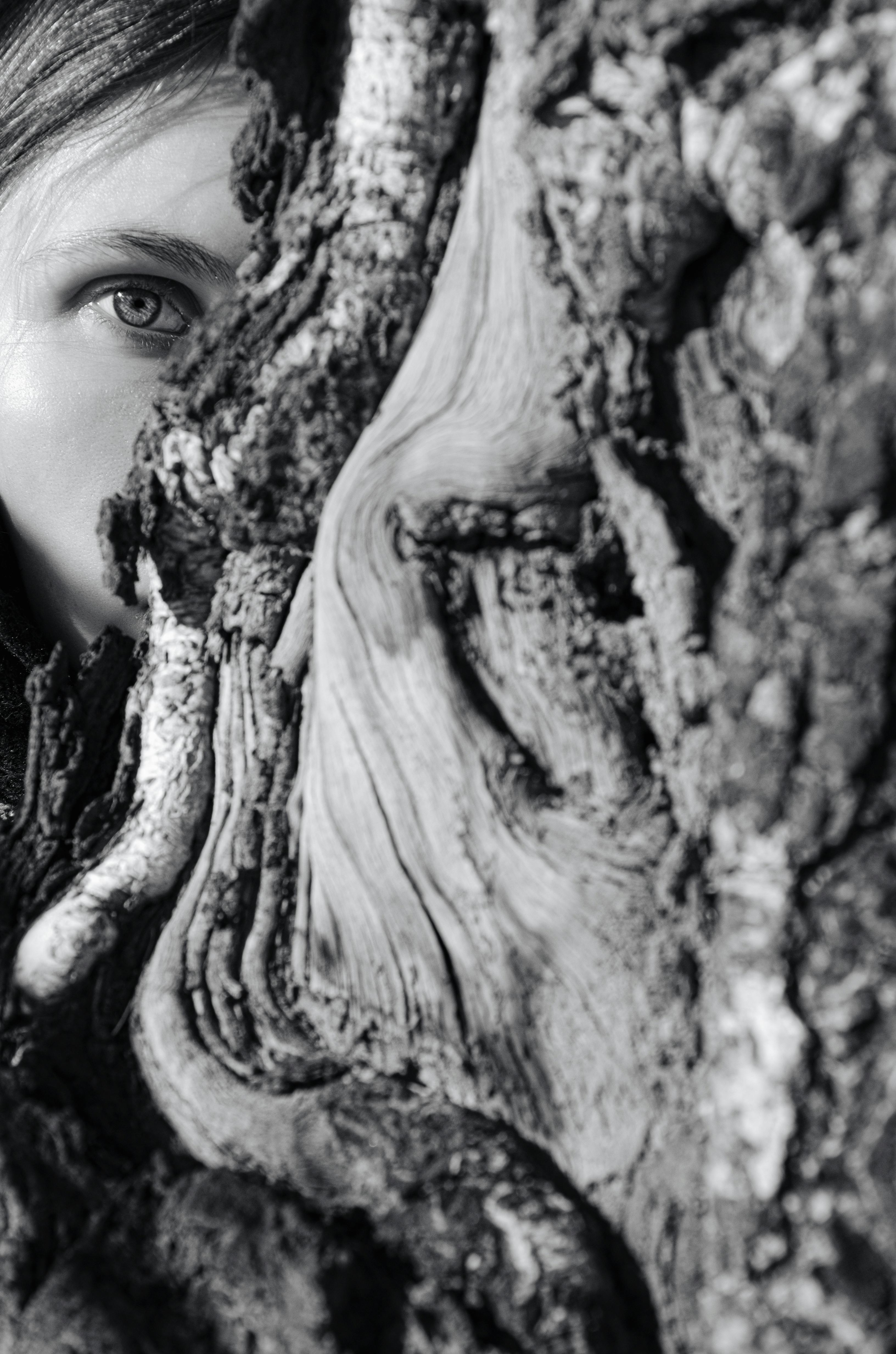 Eine Frau versteckt sich hinter einem Baum | Quelle: Pexels