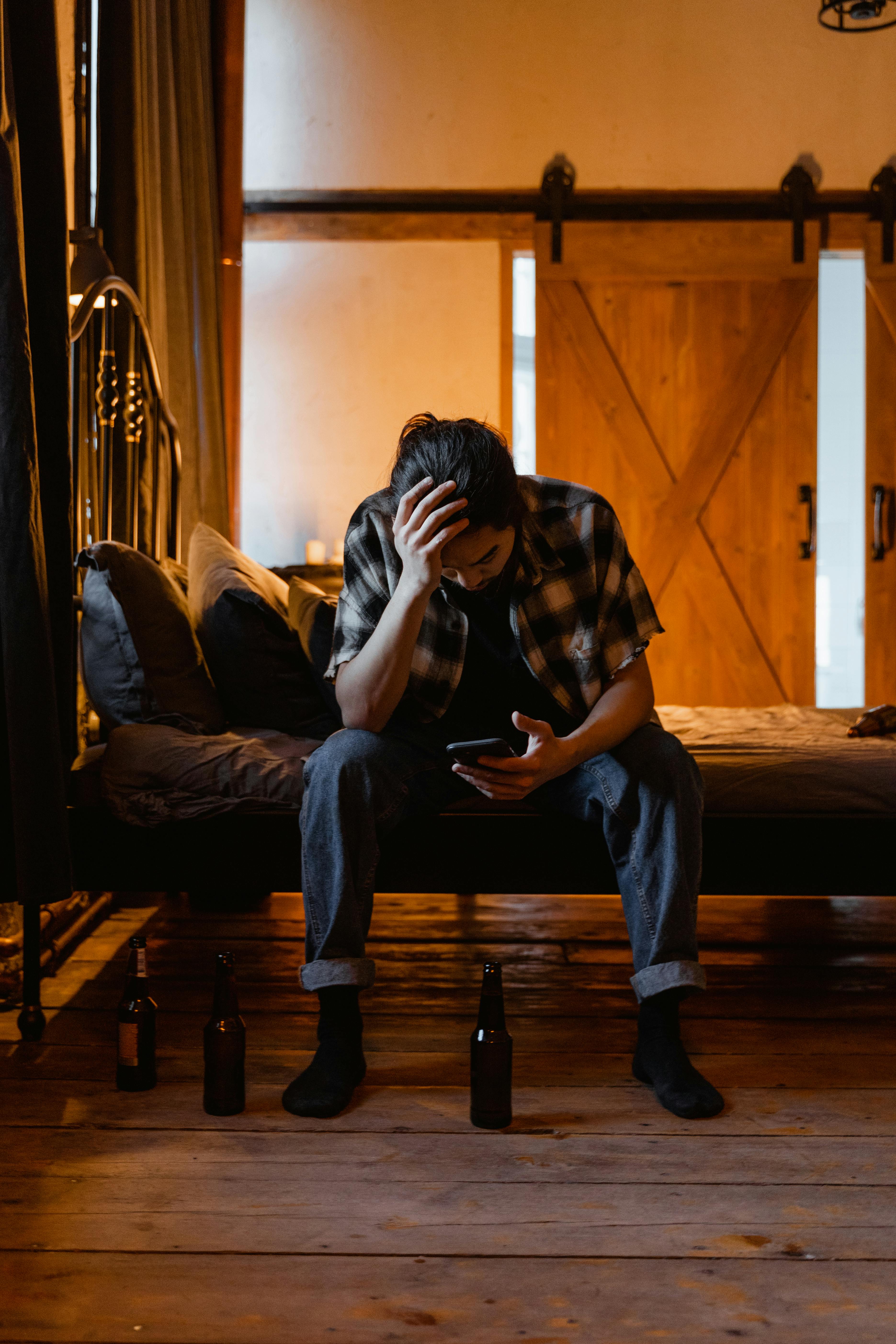 Ein müder Mann sitzt auf einem Bett | Quelle: Pexels